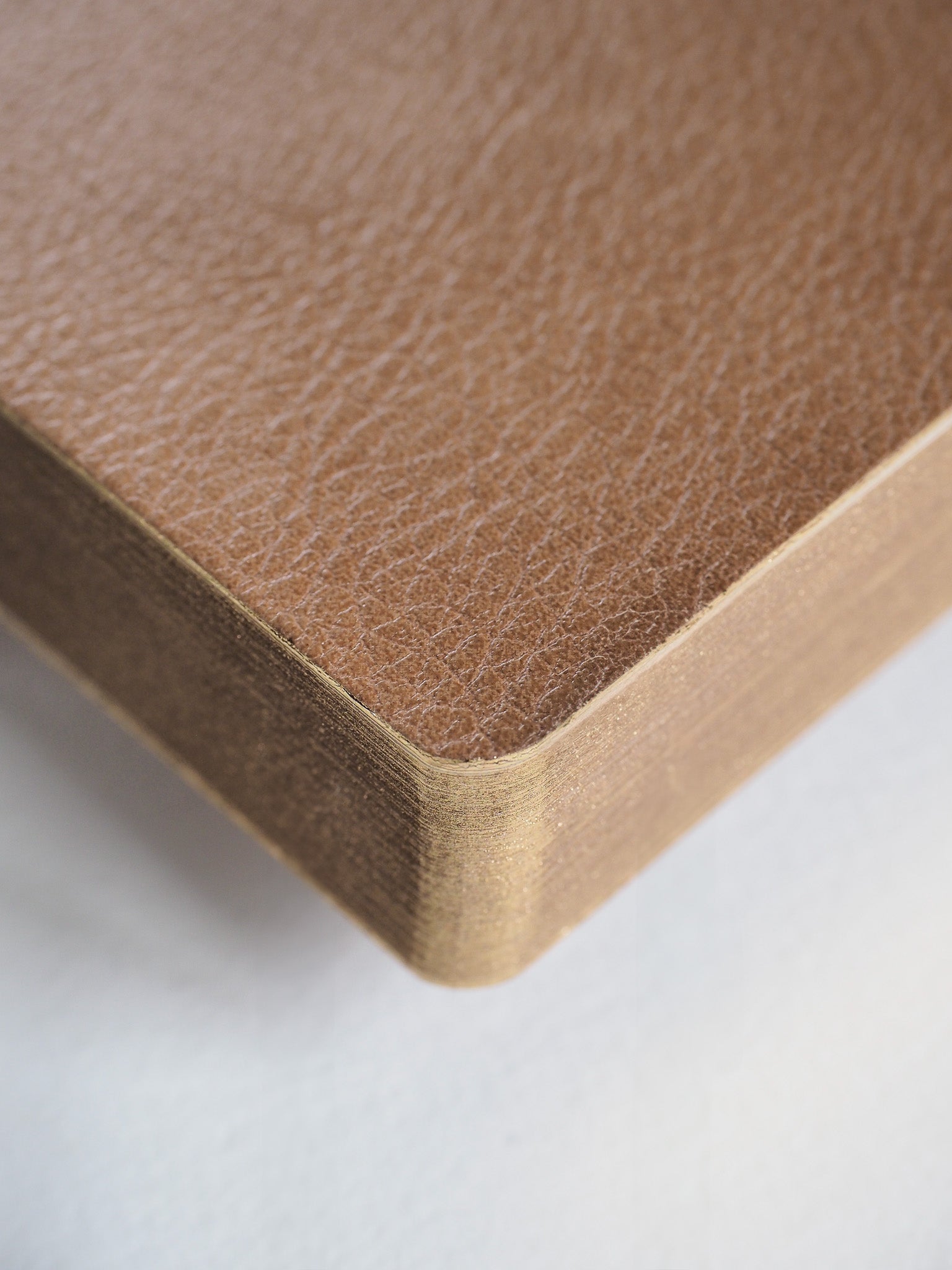 Minimalist A5 notebook featuring a smooth, solid natural kraft brown cover, perfect for structured grid note-taking or planning.