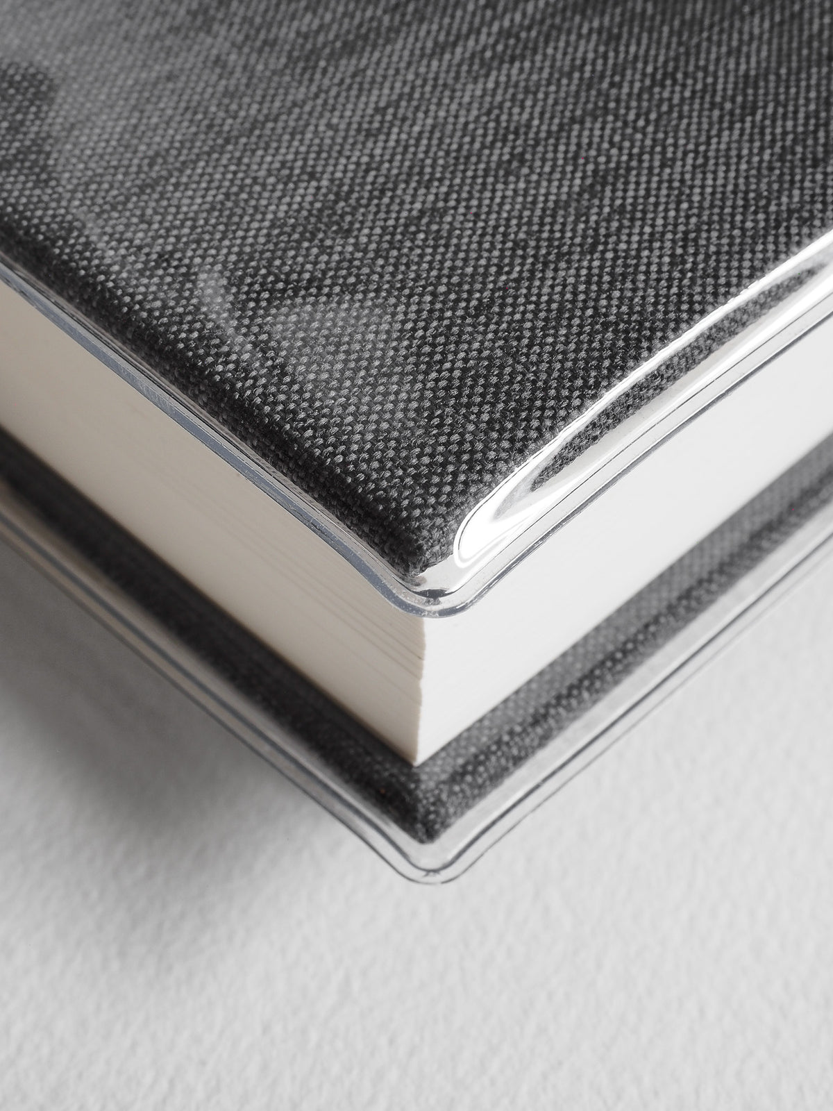 Textured charcoal gray notebook bound with a clear edge and featuring a sophisticated woven crosshatch pattern.