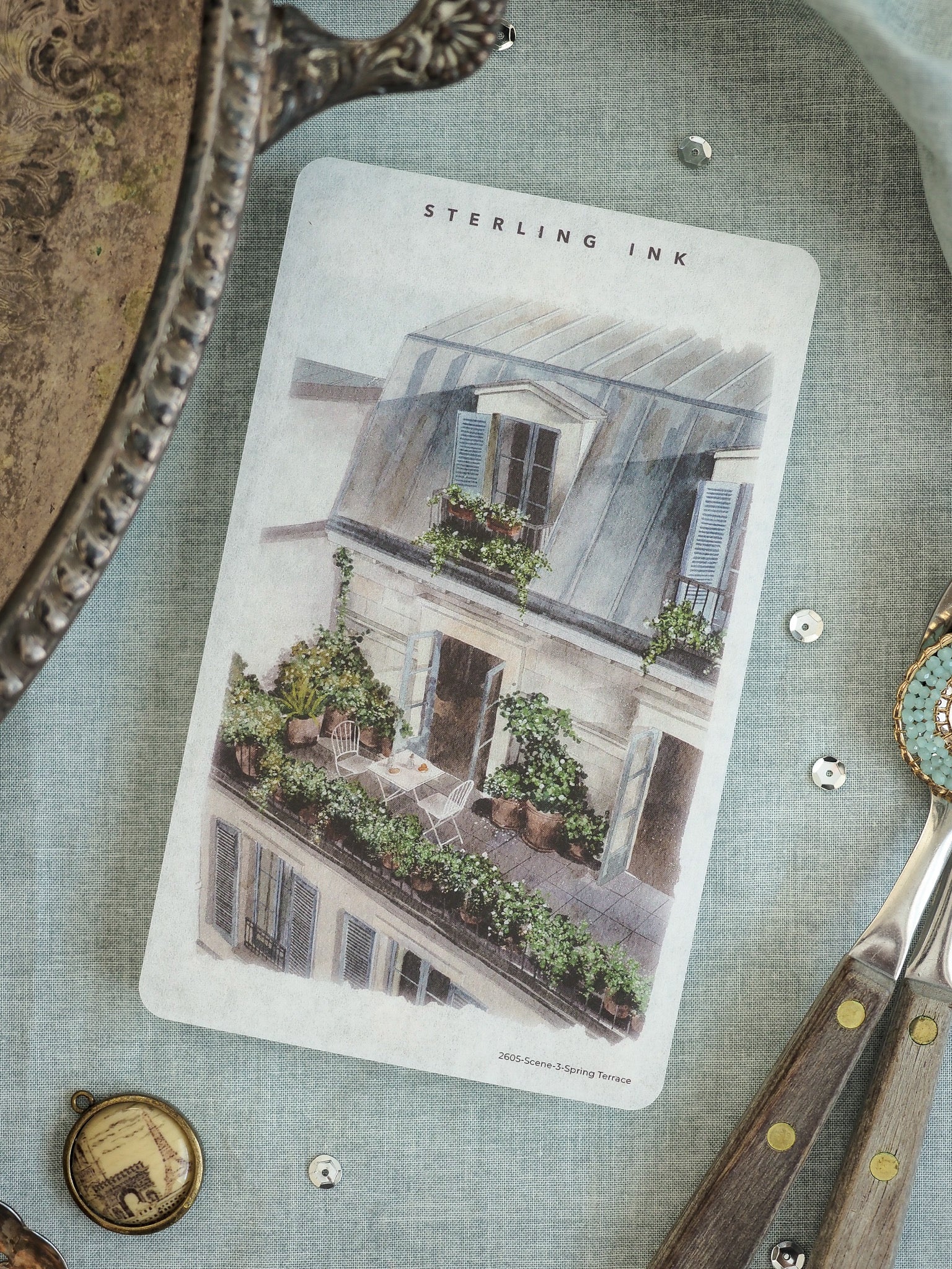 Printed illustration featuring a romantic, richly detailed old-world European balcony scene overflowing with lush potted plants and architectural charm.