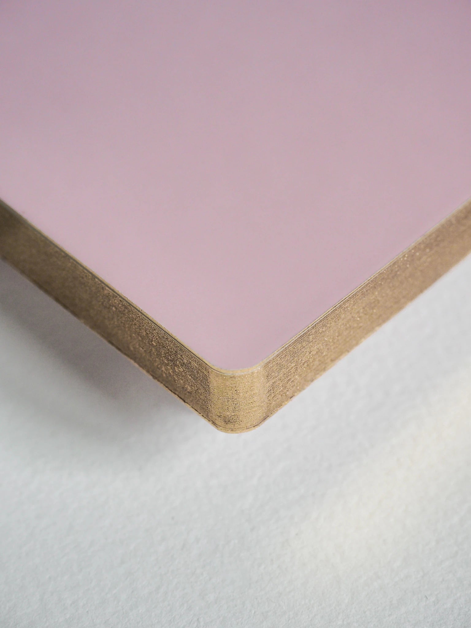 A close-up of a square pink board or panel with a natural wood edge, shown on a light gray textured surface.
#Color_Fairyfloss