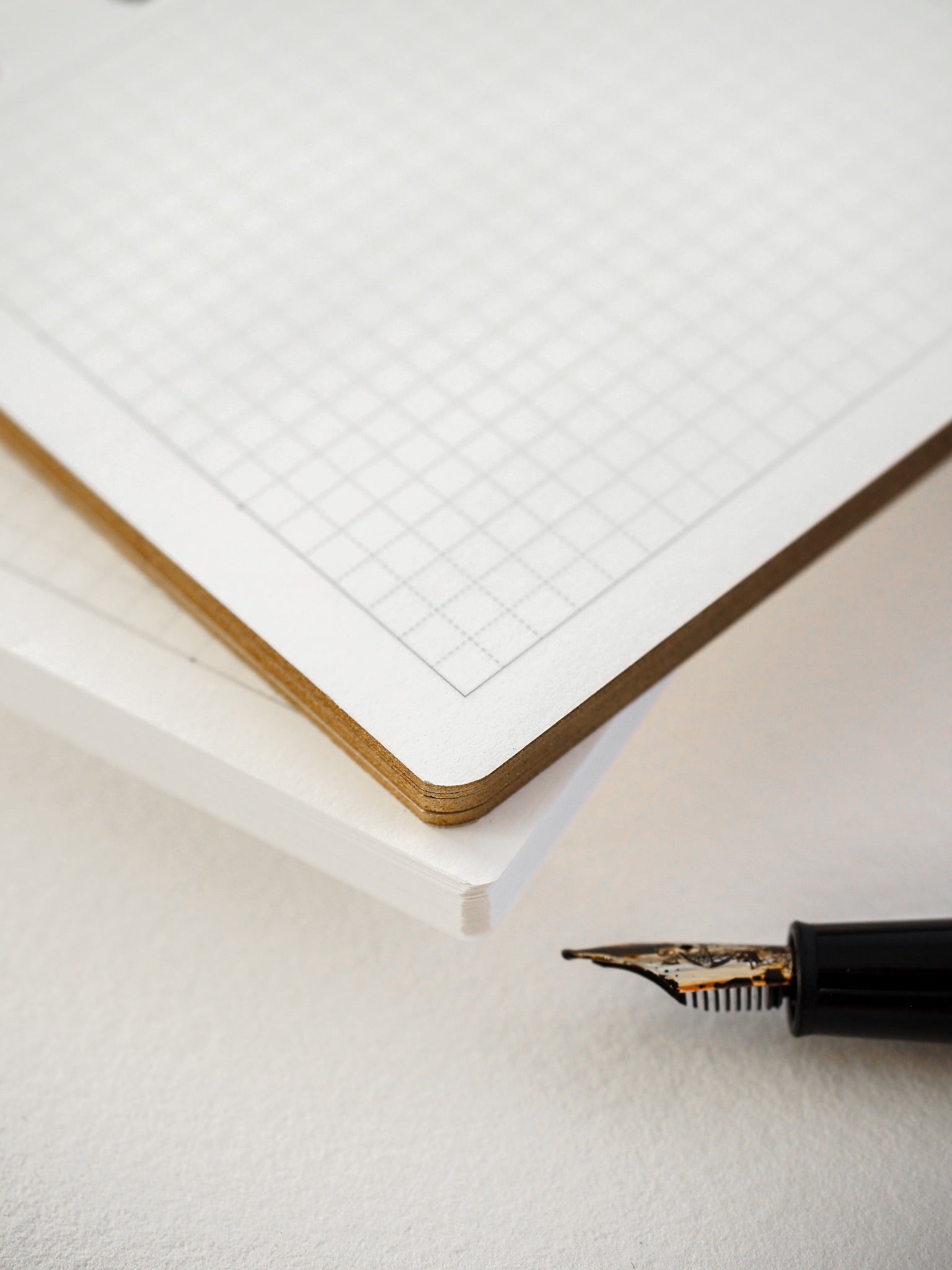 Crisp, white loose leaf paper featuring a uniform grid pattern for structured note-taking, drawing, or precise planning.