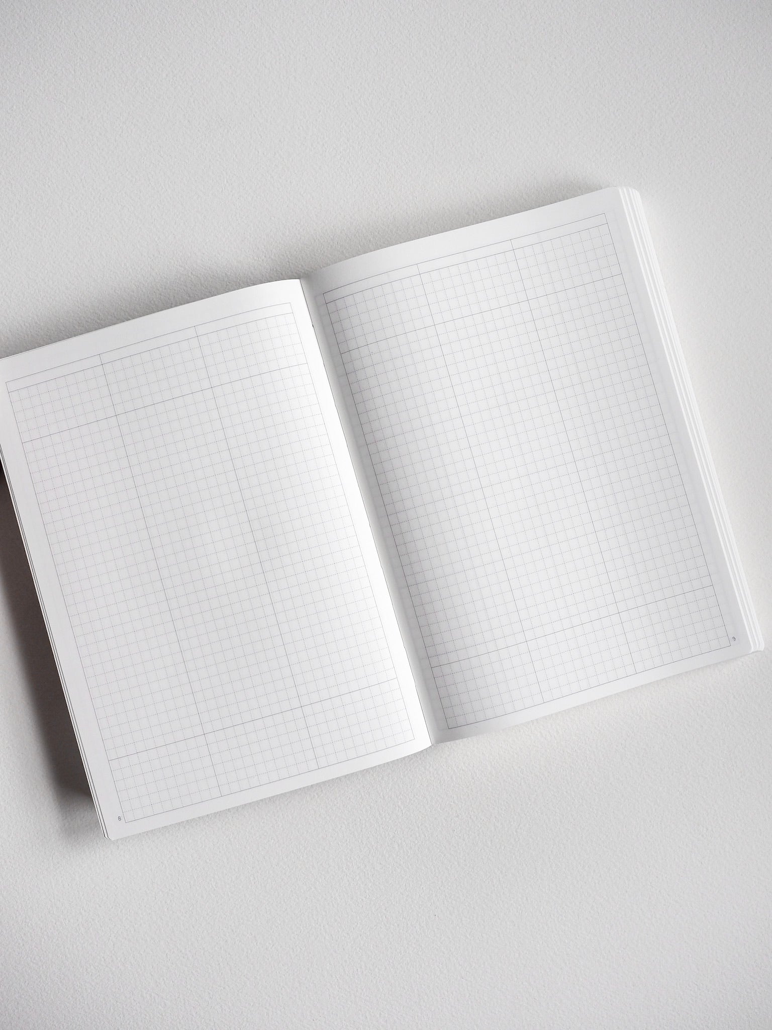Open B6 undated planner displaying fine, light-gray grid lines across two pages, perfect for daily journaling, scheduling, or tracking.