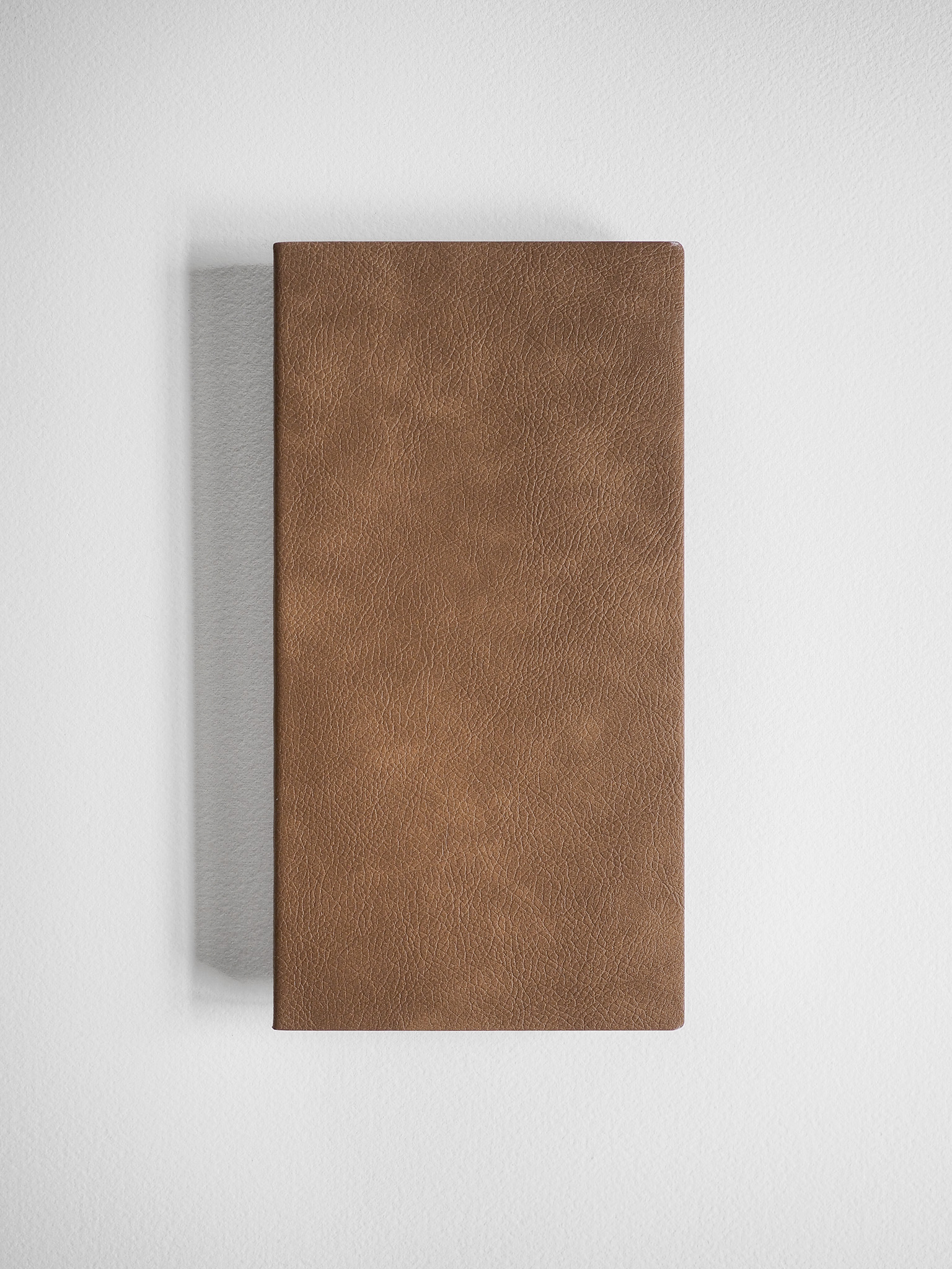 Minimalist grid notebook with a solid, textured, tan faux-leather cover, designed for writing and planning.