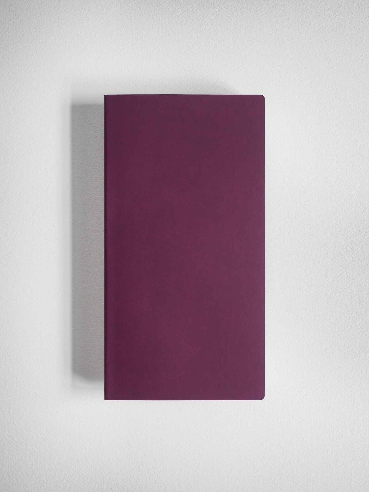 Solid, minimalist notebook with a uniform deep magenta cover, designed for grid writing and journaling.