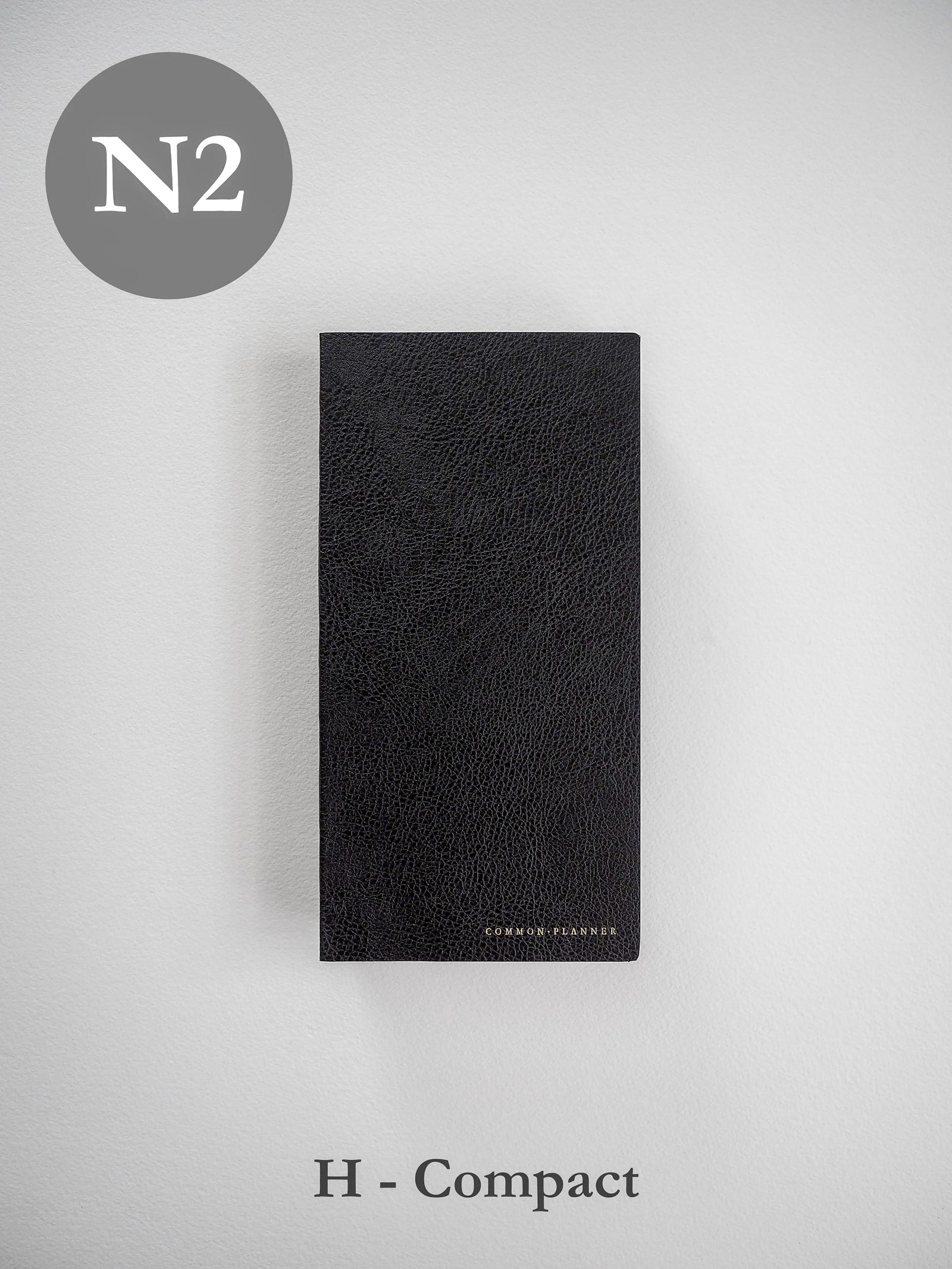 Textured black faux leather planner cover featuring a rich pebbled grain finish and subtly embossed "COMMON PLANNER" branding.