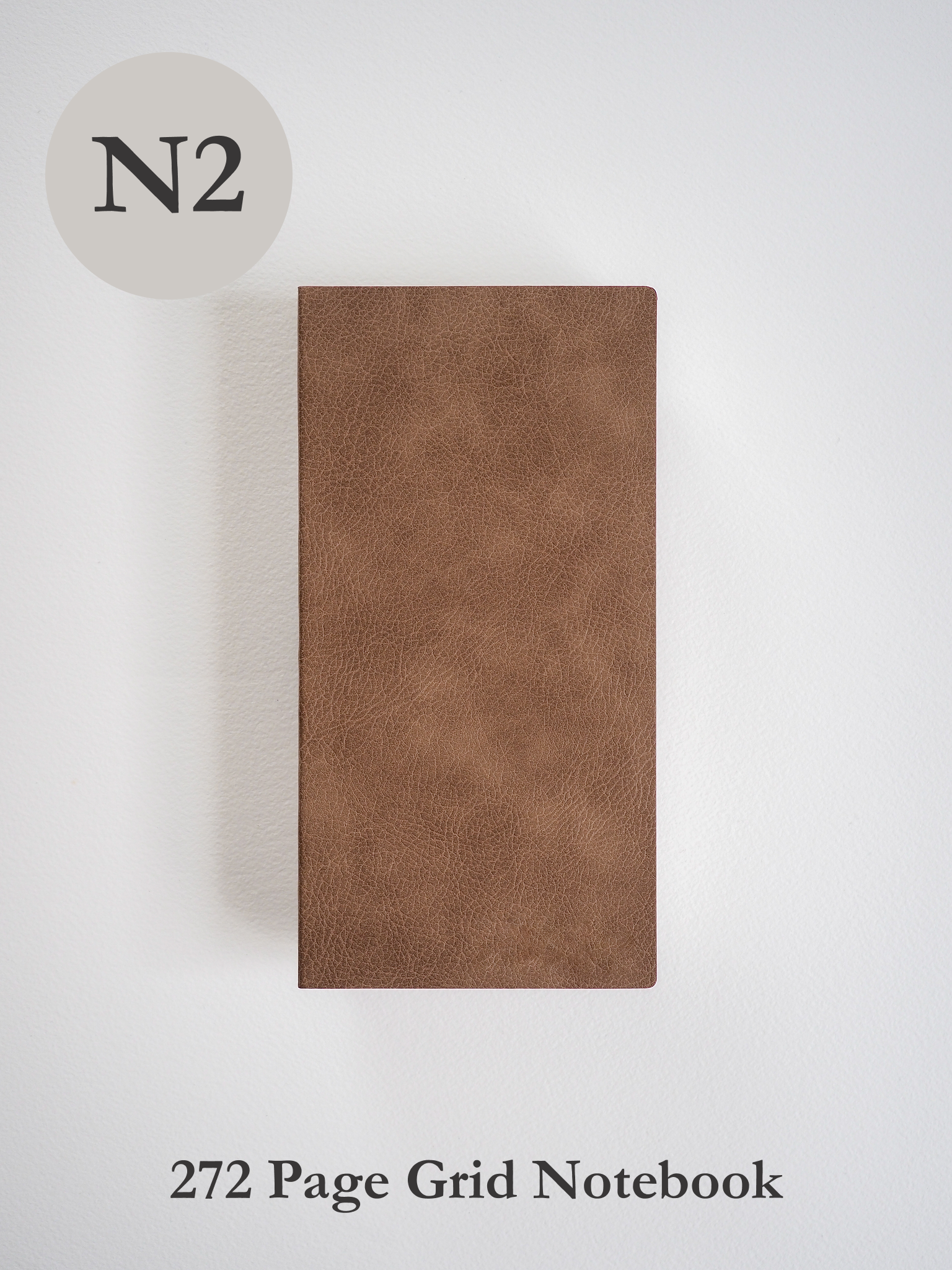 Minimalist brown notebook featuring a textured, matte faux leather cover, designed for 272 pages of gridded writing and planning.