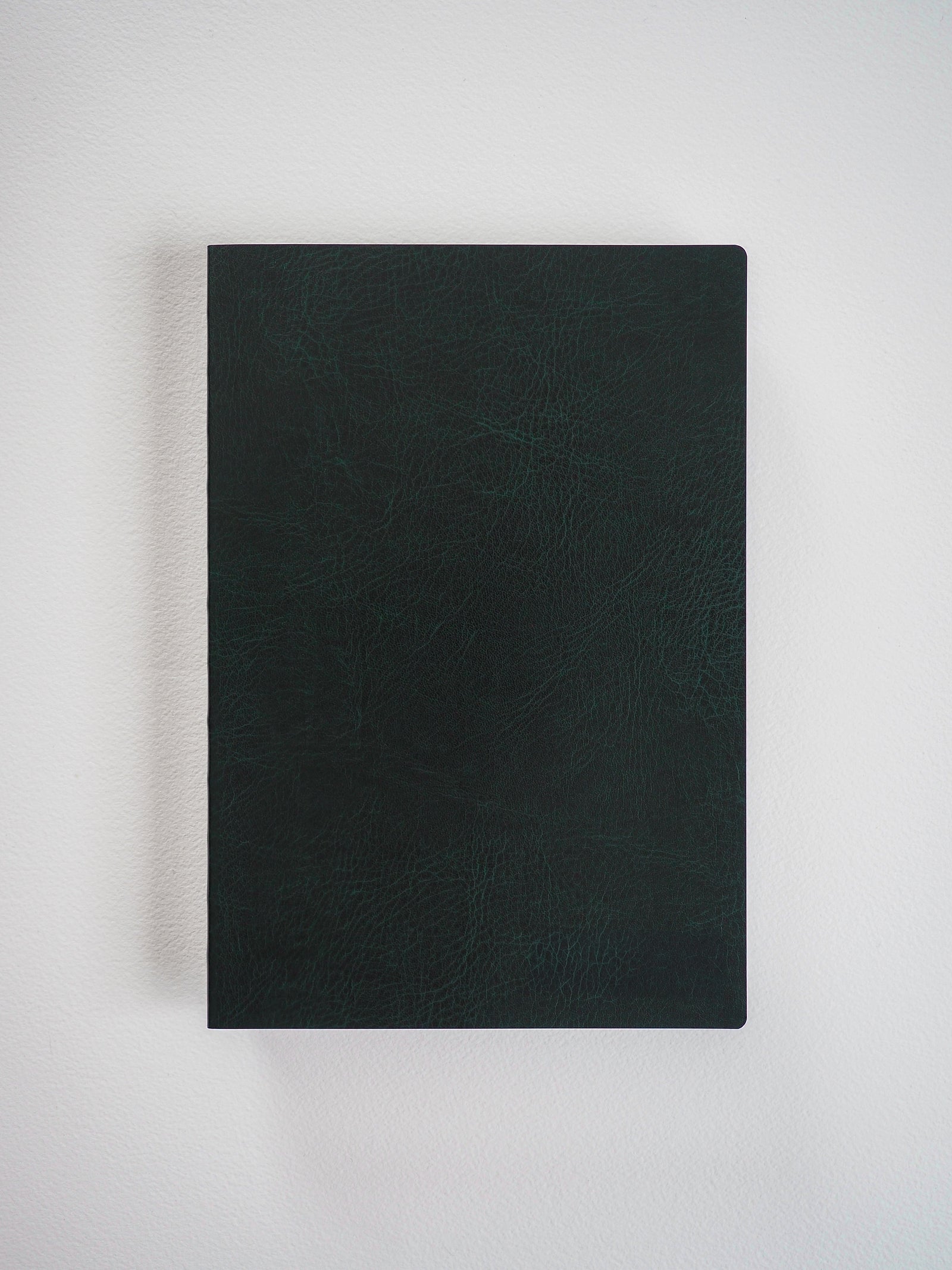 Matte black A5 grid notebook featuring a textured, sophisticated faux leather cover, perfect for detailed planning and writing.