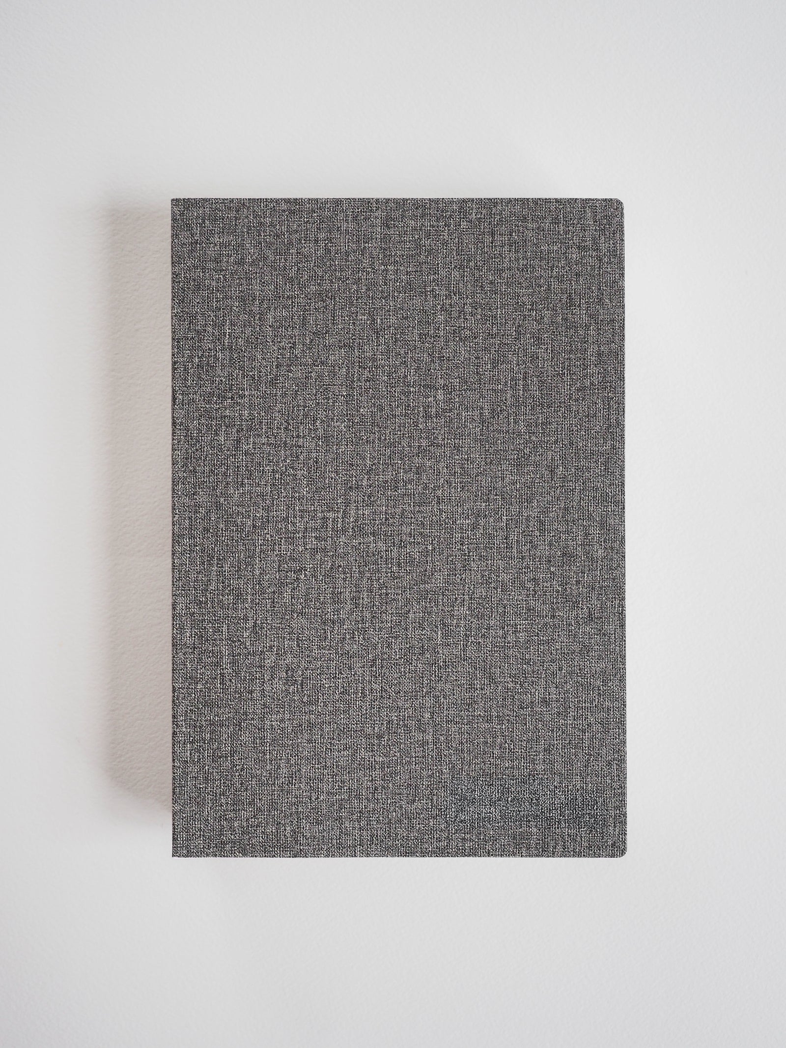 Sophisticated A5 notebook featuring a dark charcoal gray cover with a subtle, finely textured, heathered fabric finish.