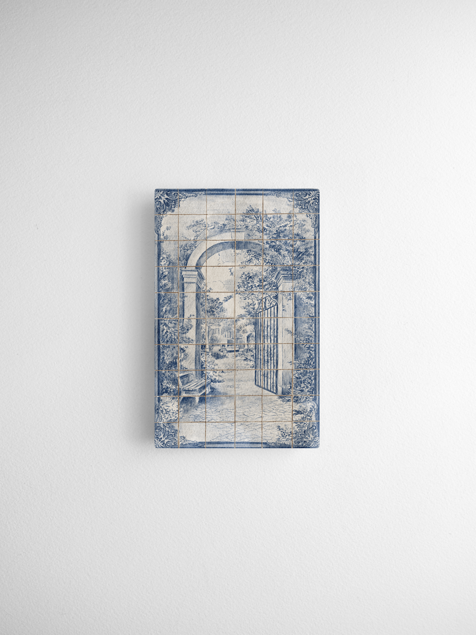 Decorative blue and white transfer print of a quaint, arched garden entrance with a wrought iron gate in a vintage tile style.