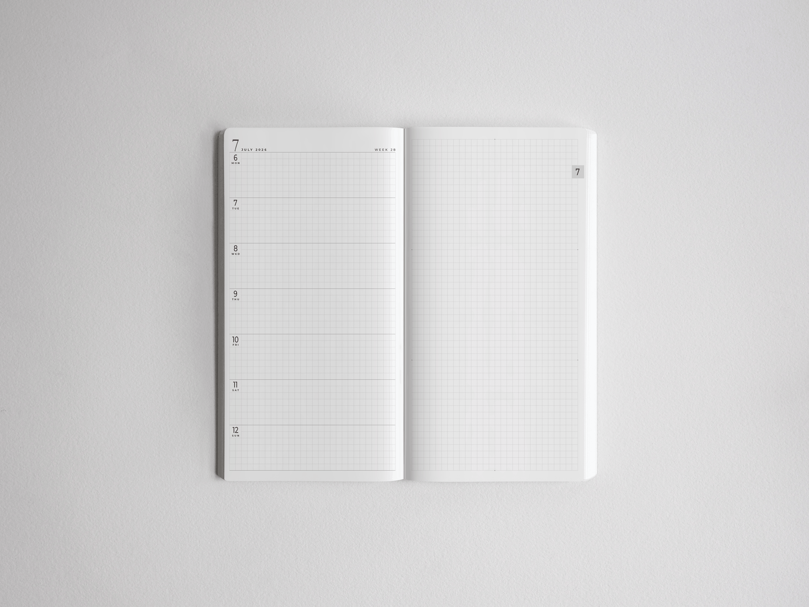 Academic full-year planner open to reveal a structured monthly date layout and complementary squared graph paper for comprehensive academic note-taking.