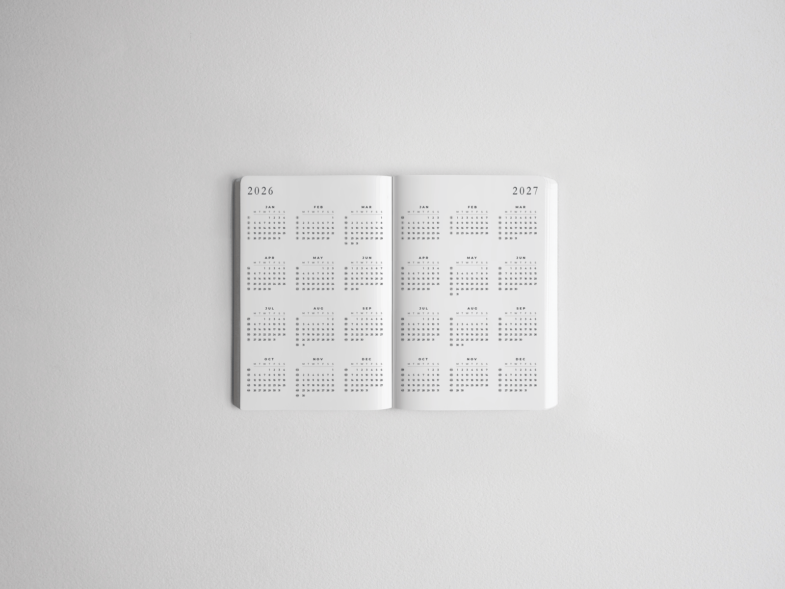 Open white pocket daily academic planner displaying detailed, full-year structured grids for both 2026 and 2027.