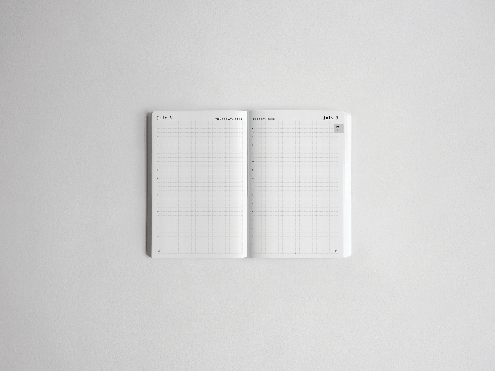 Open pocket daily planner featuring gridded, minimalist white pages perfect for academic scheduling and detailed goal tracking for 2026-2027.