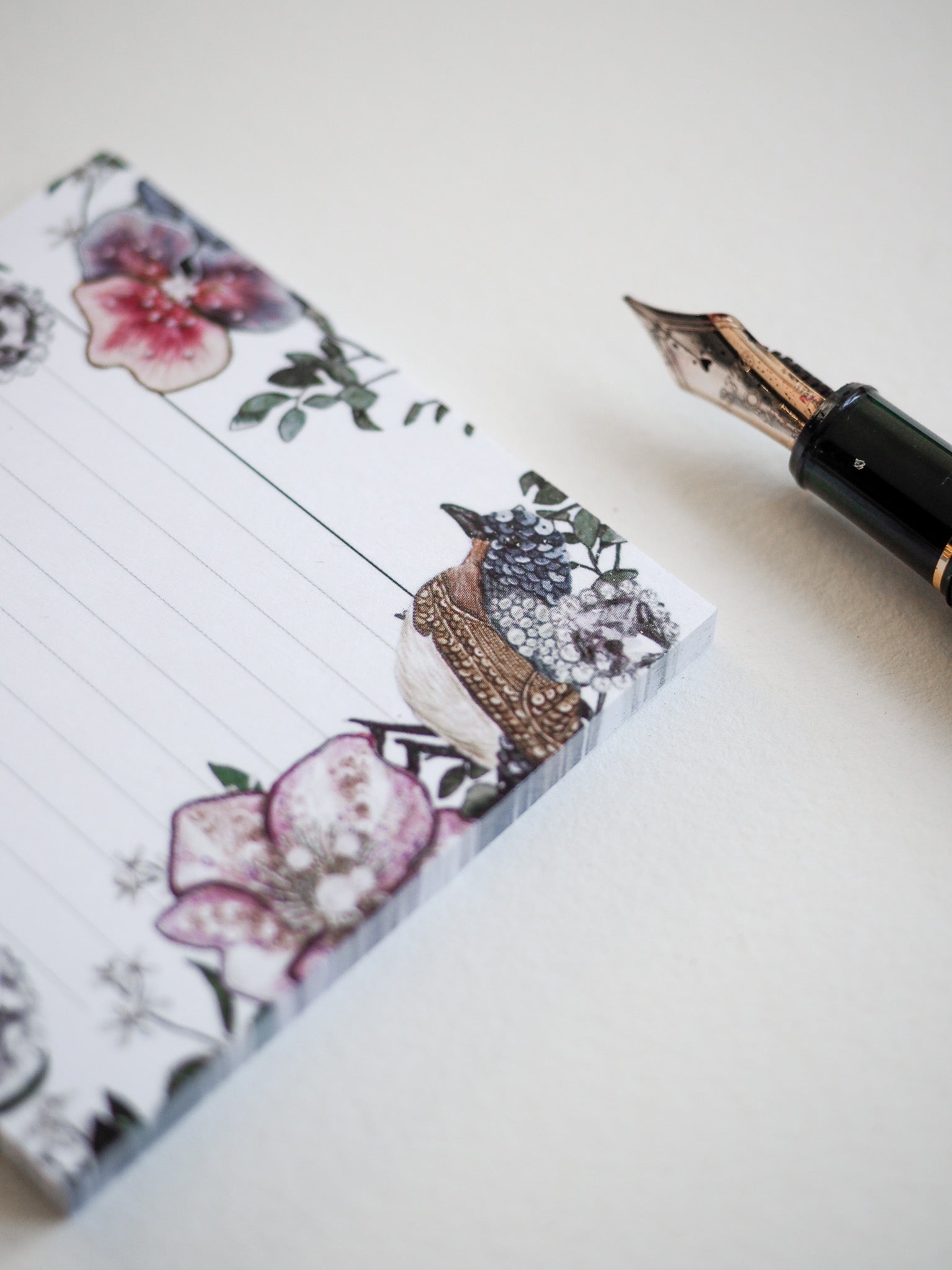 Watercolor sticky note adorned with lush pink florals, detailed green foliage, and a whimsical illustration of a small patterned bird.