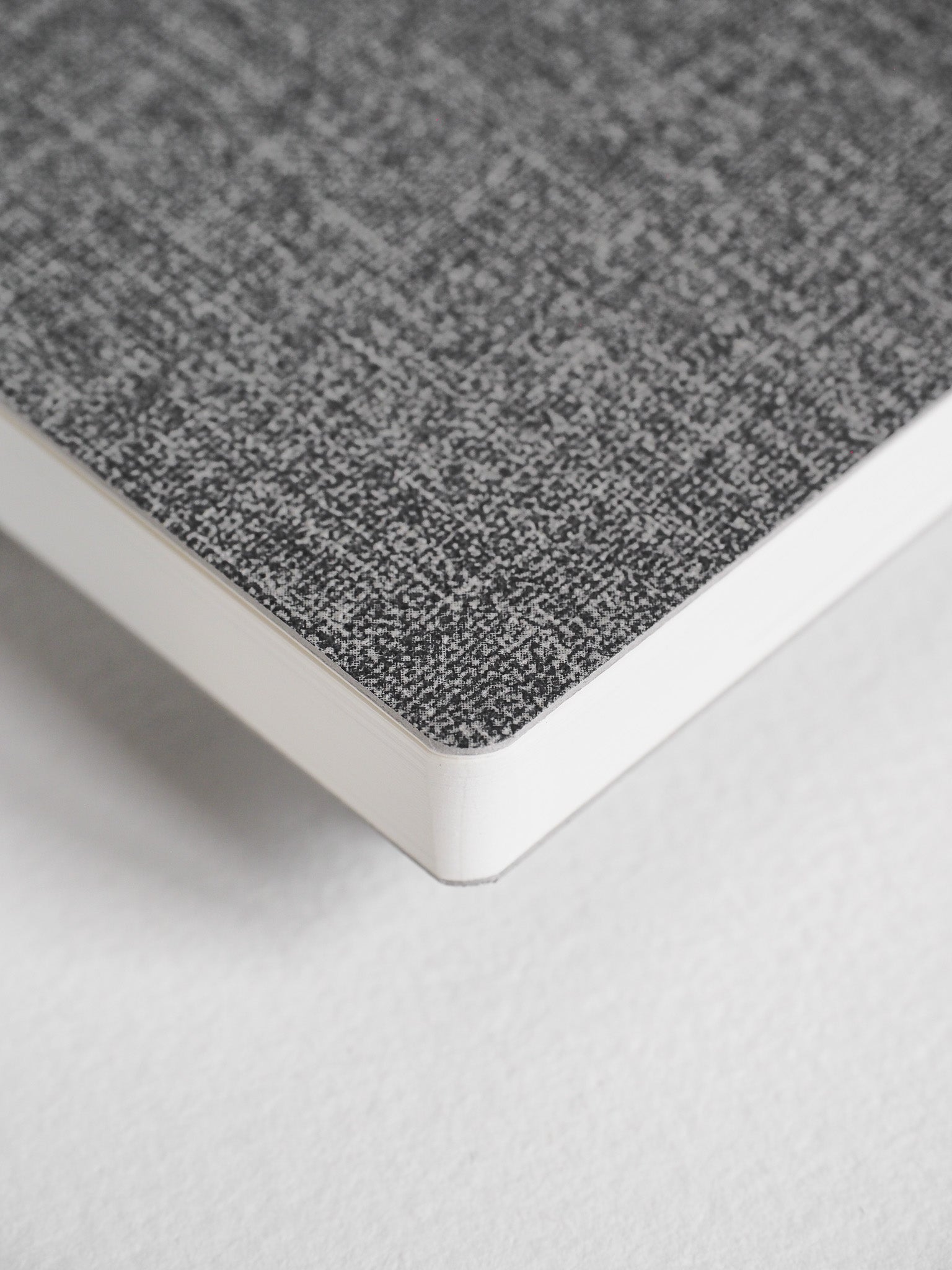 Compact planner featuring a textured, heather gray cover and crisp white edges, designed for full-year organizational planning.