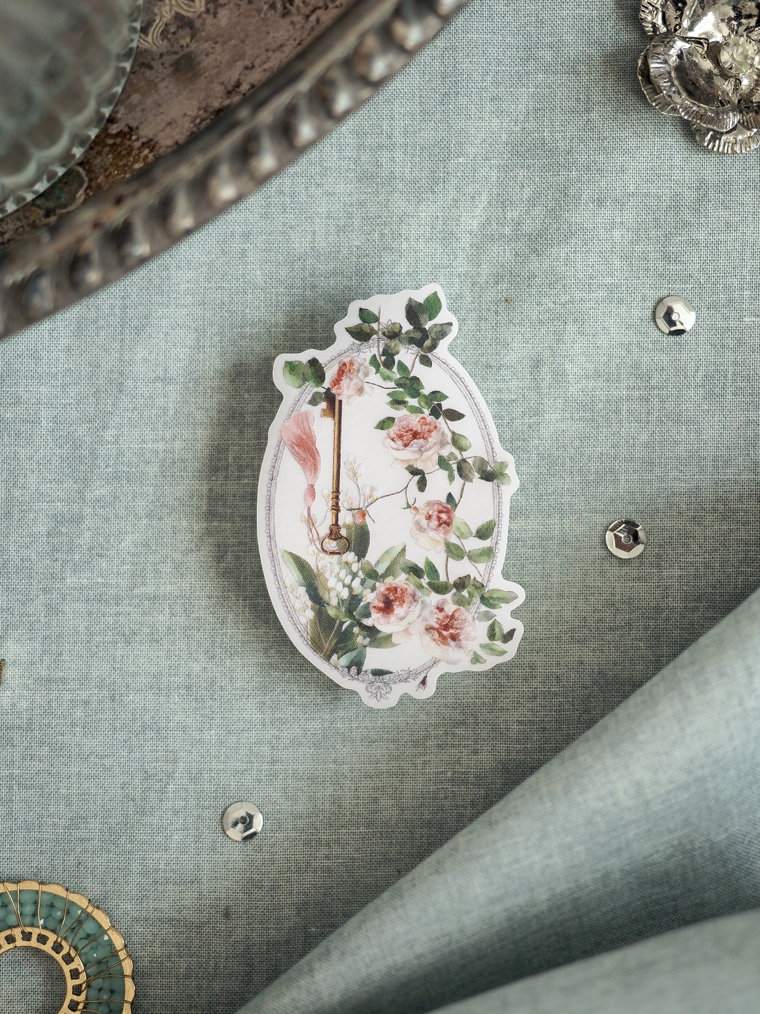 Vintage floral sticker design featuring blush roses, lush greenery, and a rustic hanging charm on an ornate, delicate apple silhouette.