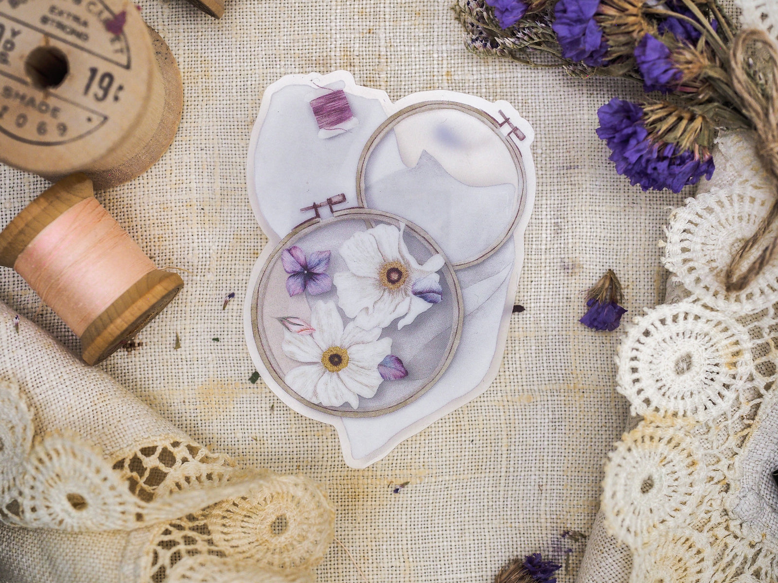 Delicate die-cut vinyl sticker sheet featuring a pale floral arrangement of white and lilac daisy-like blooms perfect for planning or journaling.