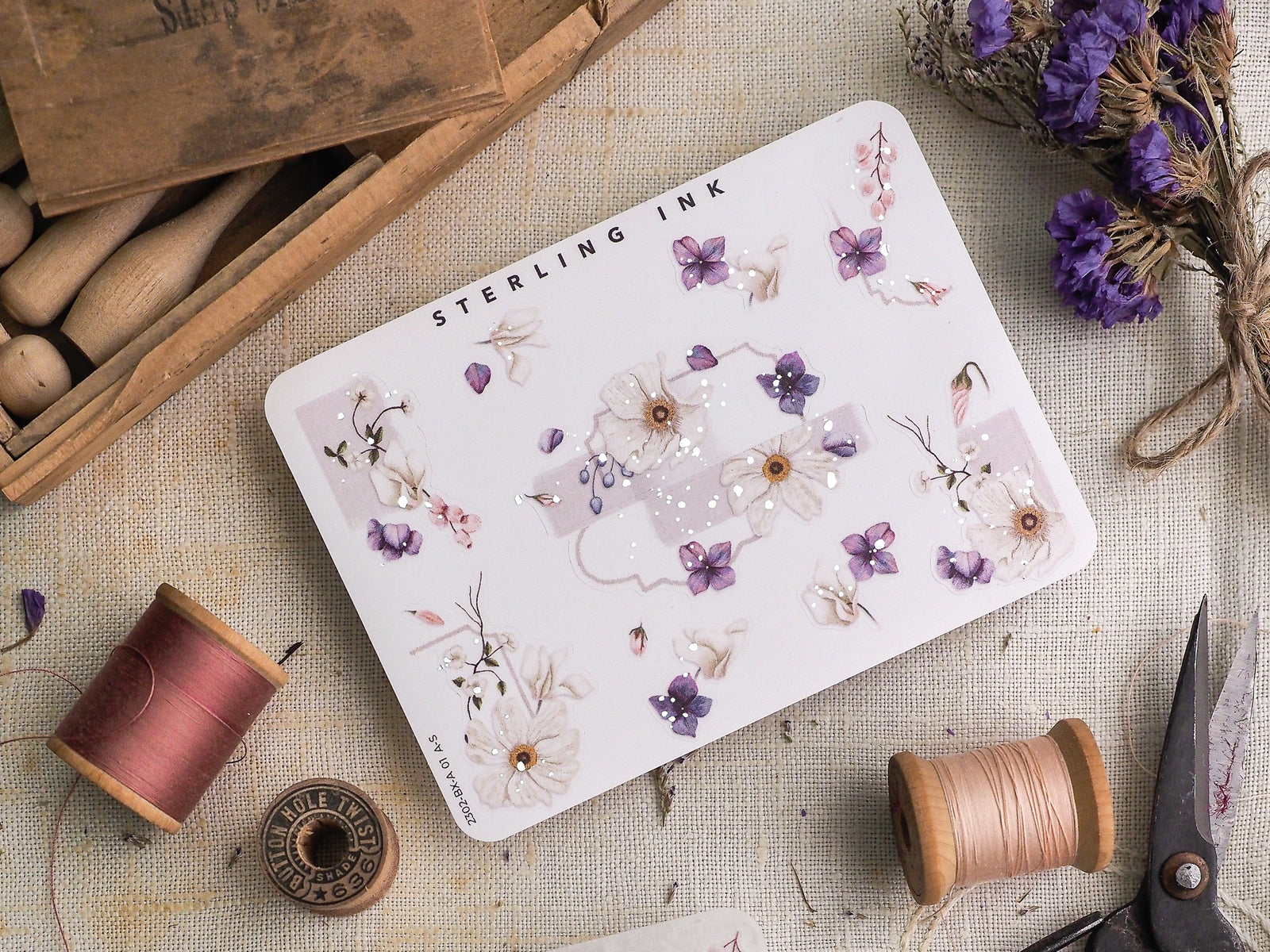 Watercolor sticker sheet featuring delicate botanical clusters of lavender, pink, and cream florals, highlighted with elegant scattered silver foil accents.
