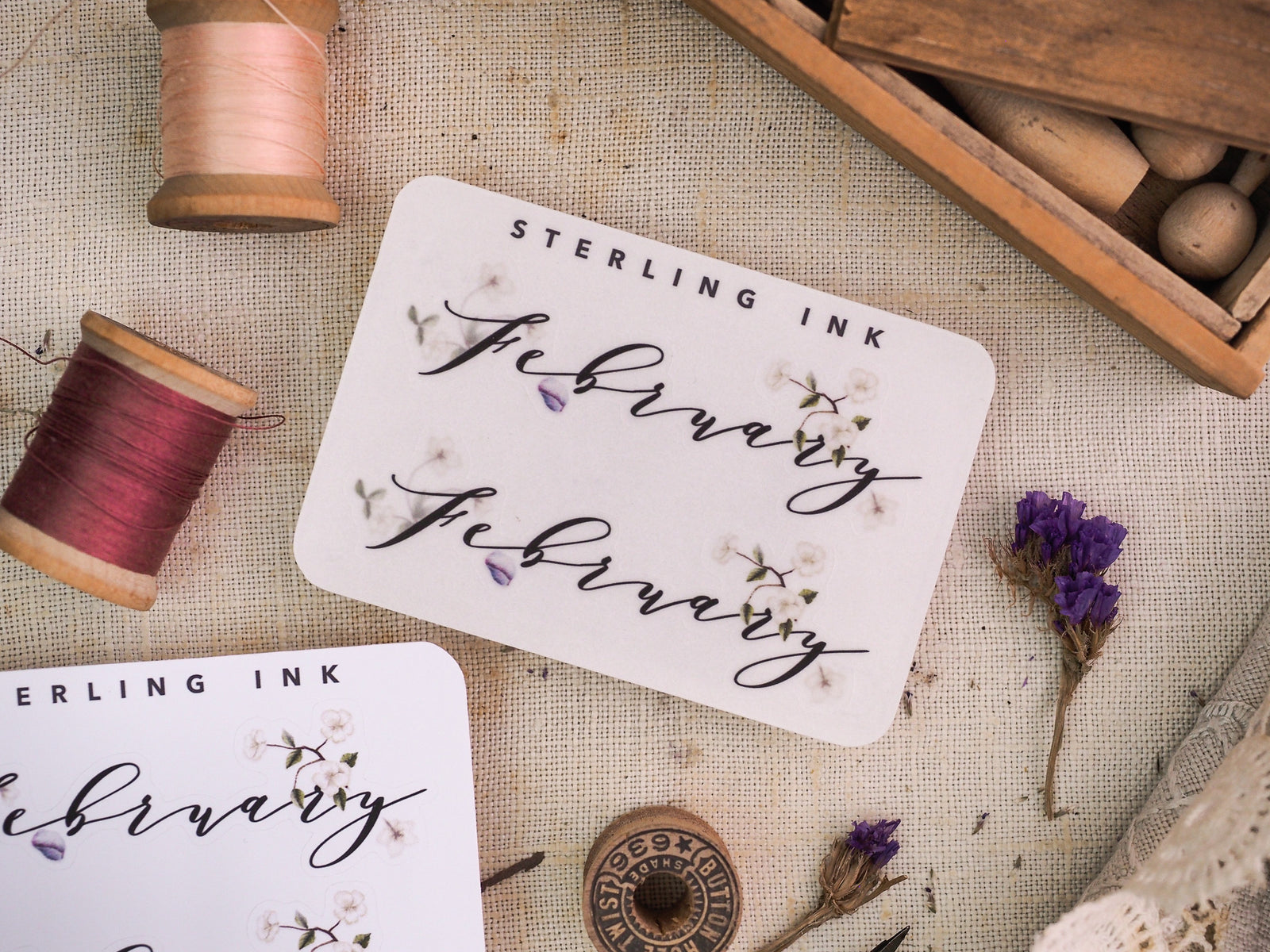 Elegant "Sterling Ink" monthly sticker set for February, featuring delicate script lettering, small butterflies, and watercolor floral accents for journaling and planning.