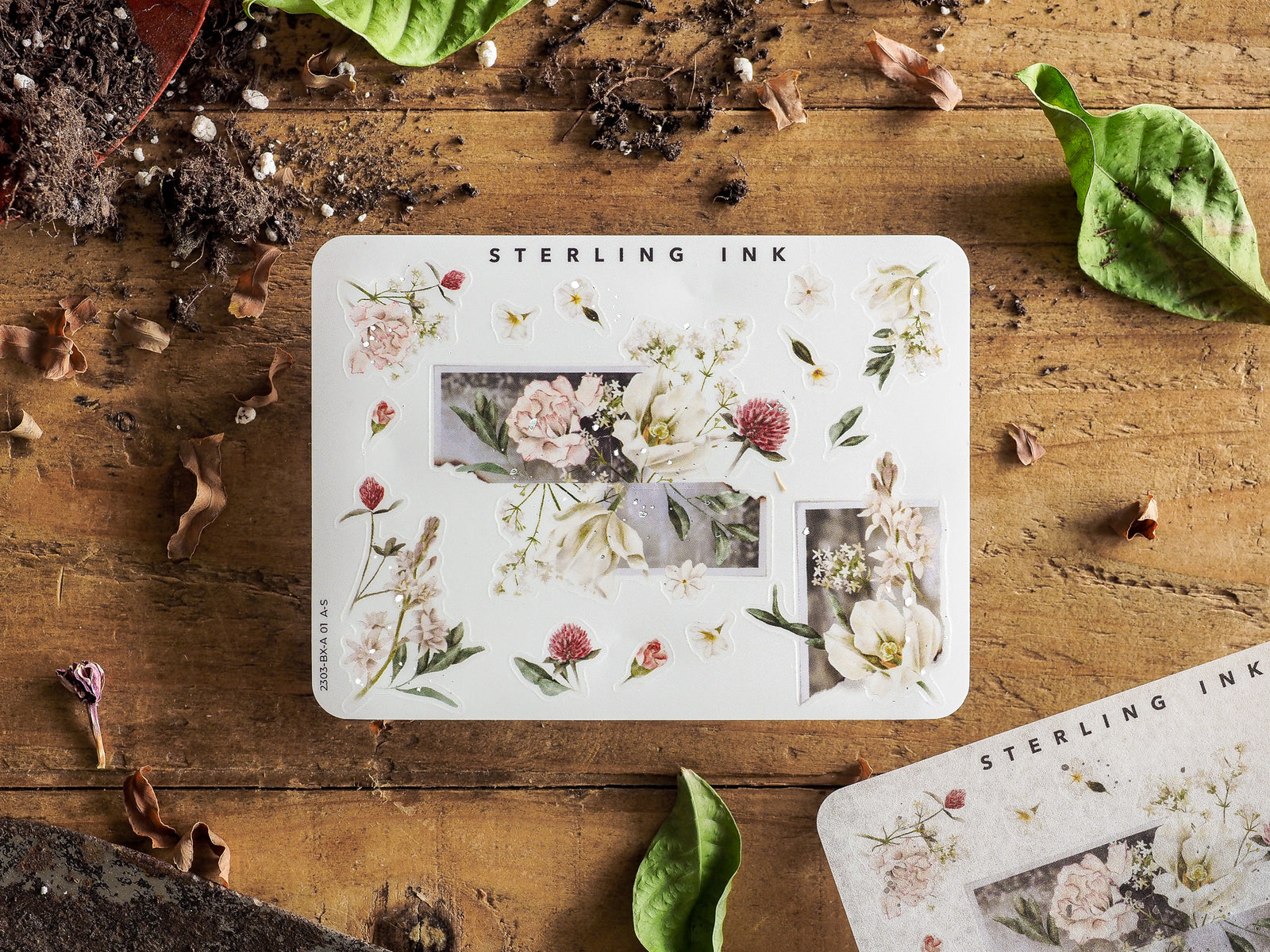 Botanical corner and edge stickers on white paper, showcasing delicate arrangements of cream and blush pink flowers with subtle silver accents.