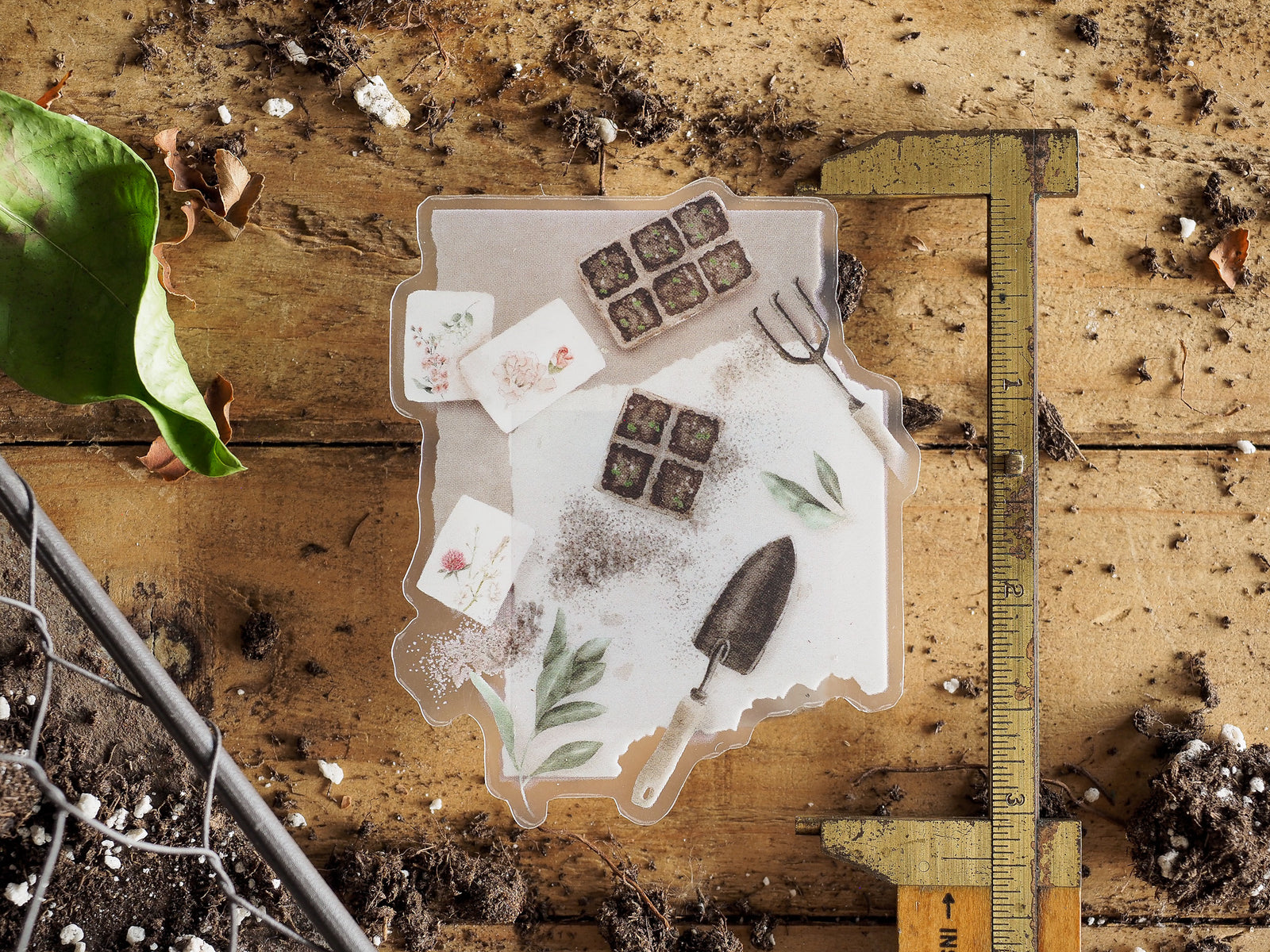 Die-cut vinyl stickers featuring a whimsical spring gardening theme, including floral decals, seed pots, and miniature gardening tools.
