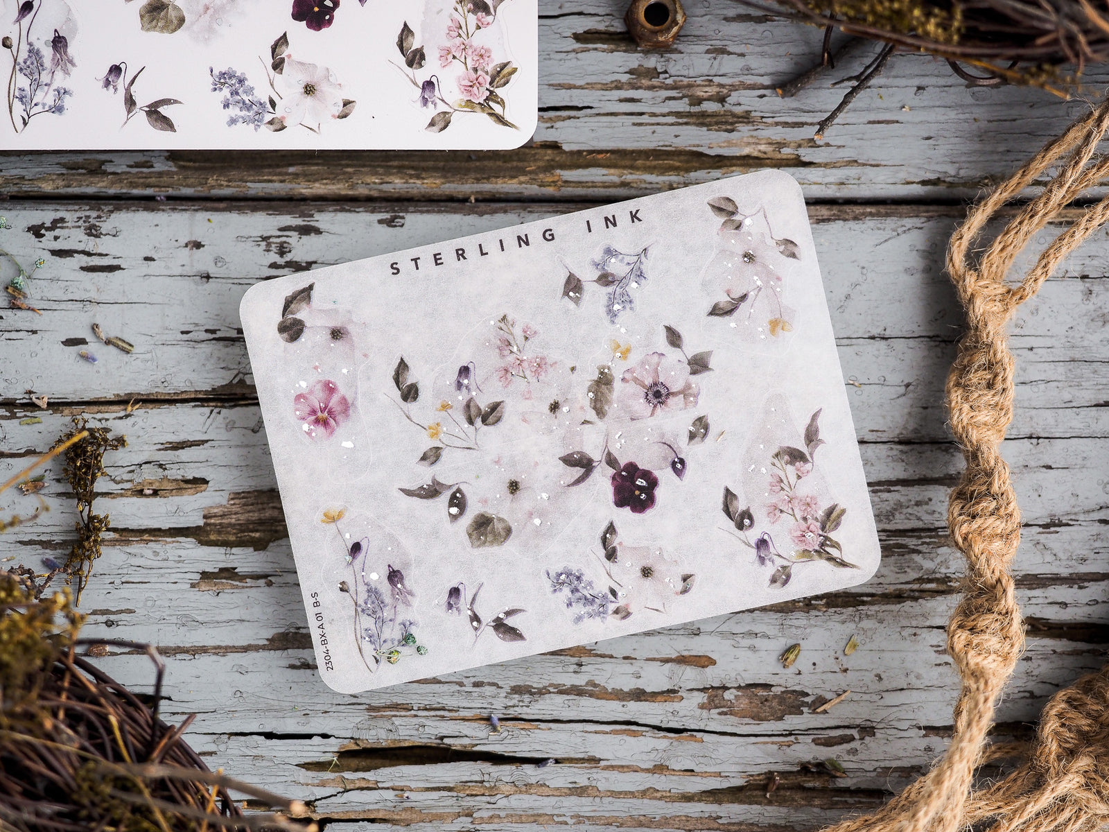 Delicate sticker sheet featuring watercolor floral clusters of purples and pinks, perfect for adding decorative touches to journals and planners.