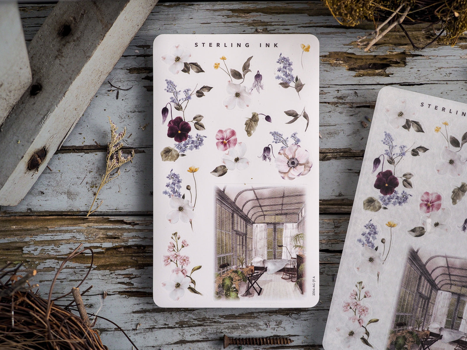 Decorative sticker sheet featuring an arrangement of watercolor floral illustrations and a central scenic watercolor image of an elegant conservatory.