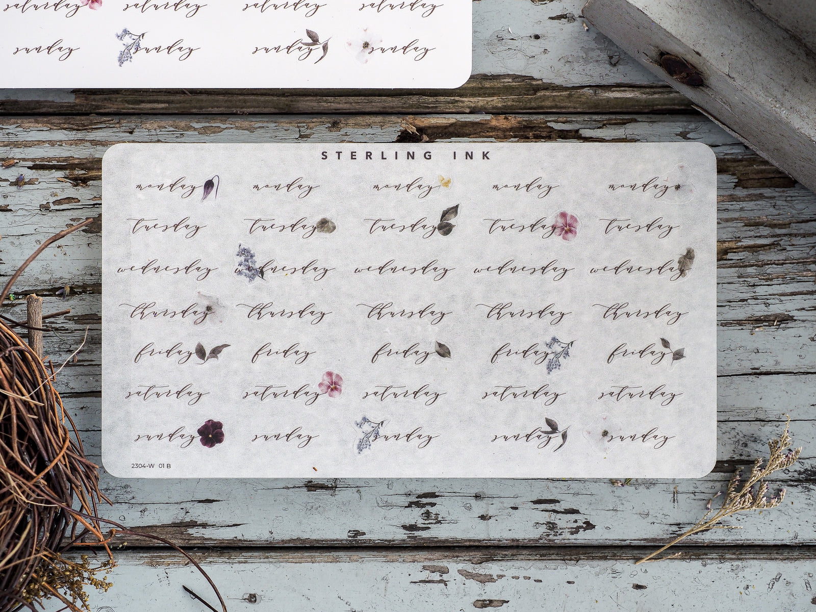Delicate weekly sticker set featuring dates and weekdays (Monday through Sunday) decorated with small, scattered watercolor florals on cream paper.