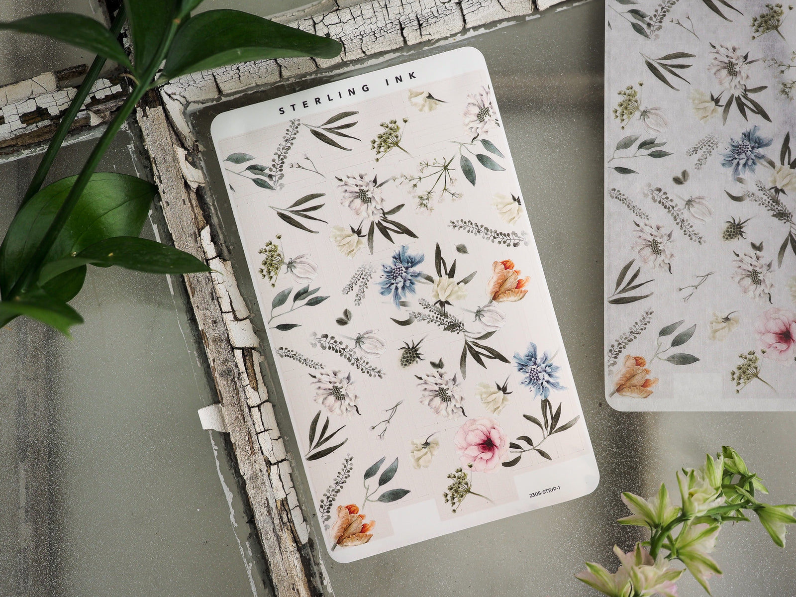 Delicate watercolor floral sticker strip featuring a soft botanical wreath pattern with muted blues, blush pinks, and sage green leaves.