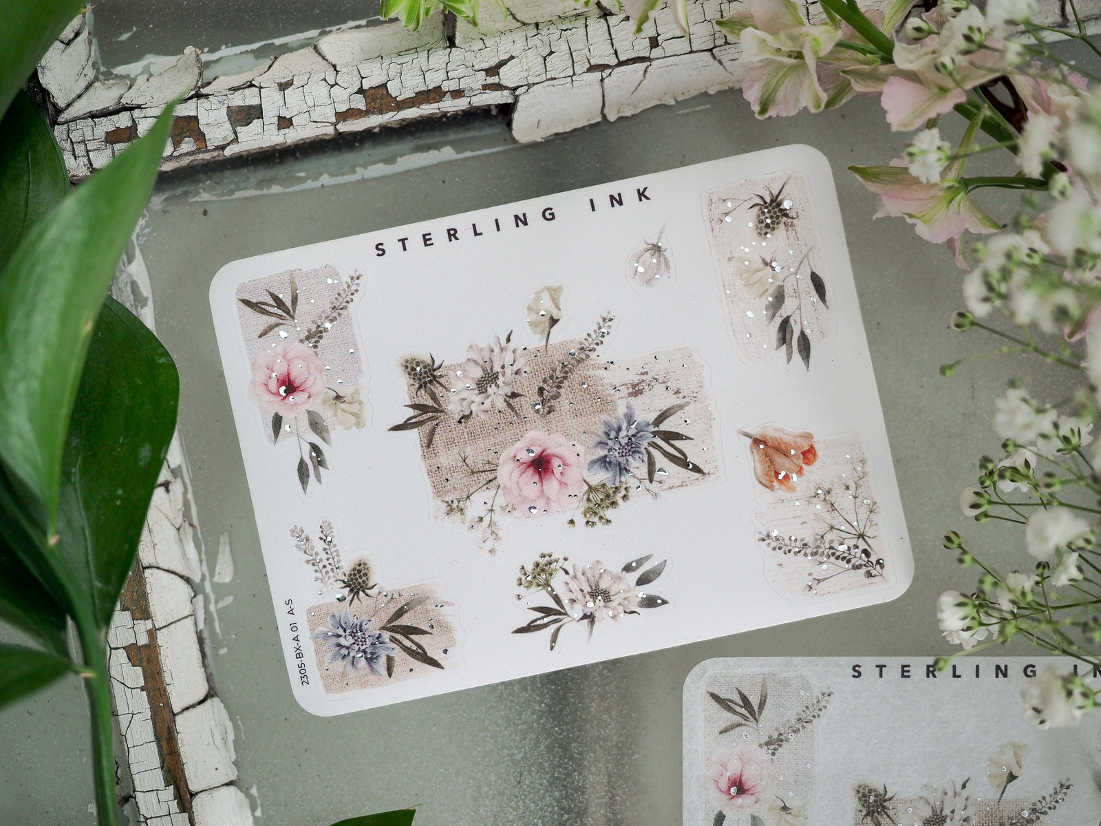 Intricate sticker sheet adorned with delicate, romantic floral clusters, dried botanical elements, and shimmering silver foil accents.