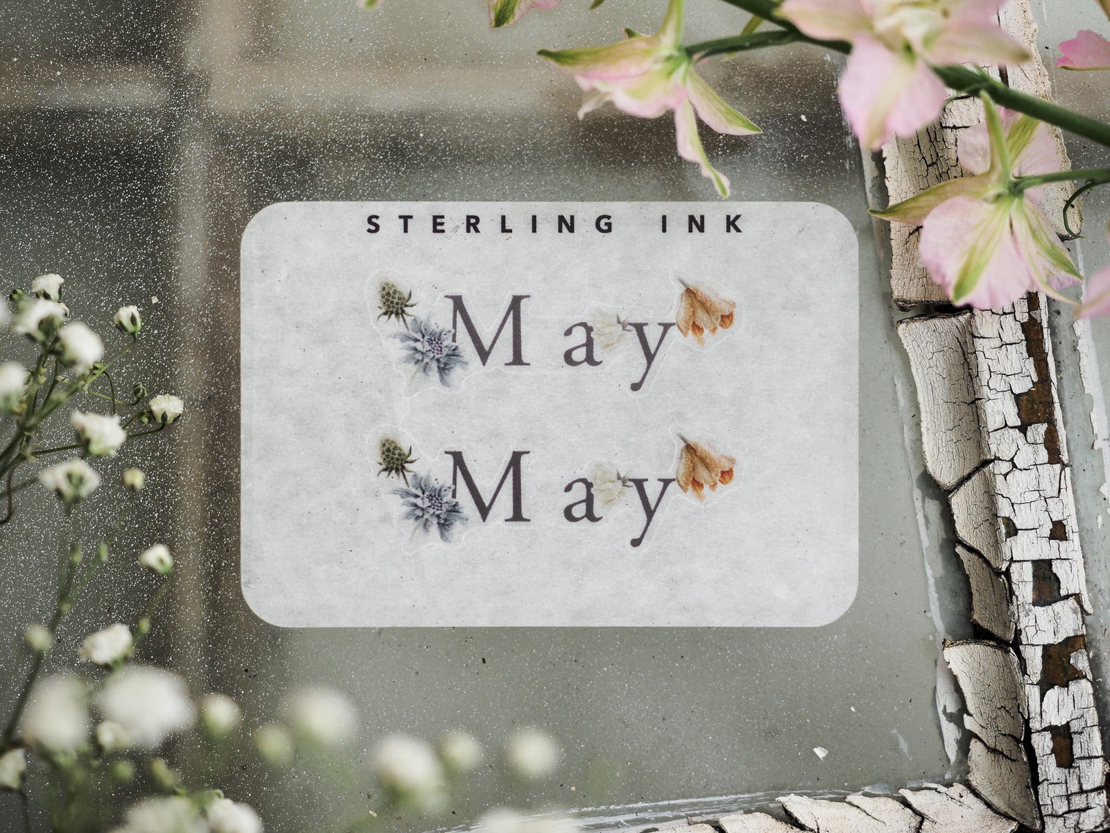 Spring-themed May month sticker featuring a pale background, elegant text, and delicate watercolor illustrations of blue and apricot spring florals.