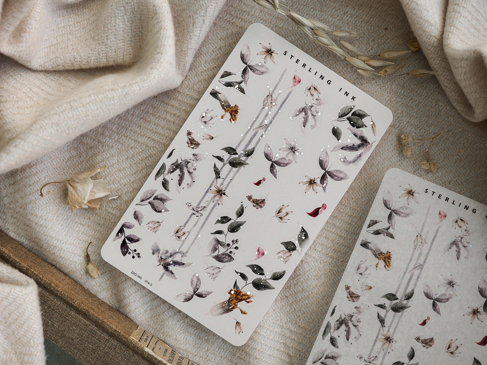 Botanical washi strip sticker sheet with muted, earthy tones and delicate depictions of leaves, small flowers, and subtle glittering accents.