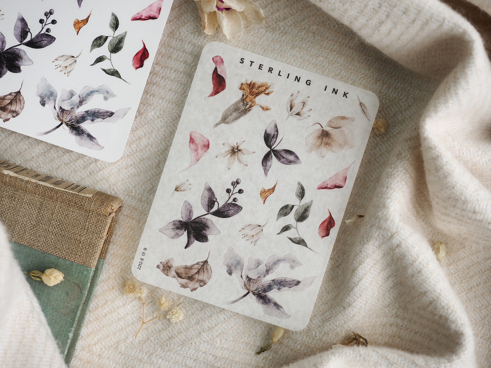 Botanical sticker sheet displaying watercolor illustrations of delicate autumn leaves, small flowers, and dried botanical elements in muted, earthy tones.