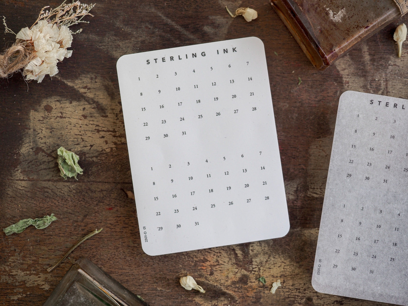White printed calendar card displaying a detailed black numerical grid for daily dates, labeled "Sterling Ink," designed for planning and organization.