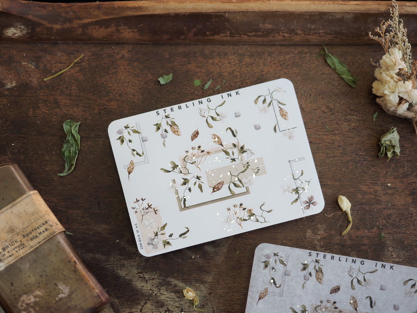 Elegant sticker set featuring delicate botanical elements, greenery, and pale watercolor floral motifs accented with subtle silver foil details.