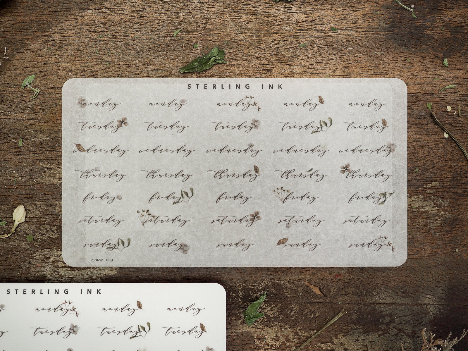 Rustic off-white sticker sheets designed for planning, displaying weekly days like Monday through Sunday in an elegant, vintage script perfect for journaling and calendars.