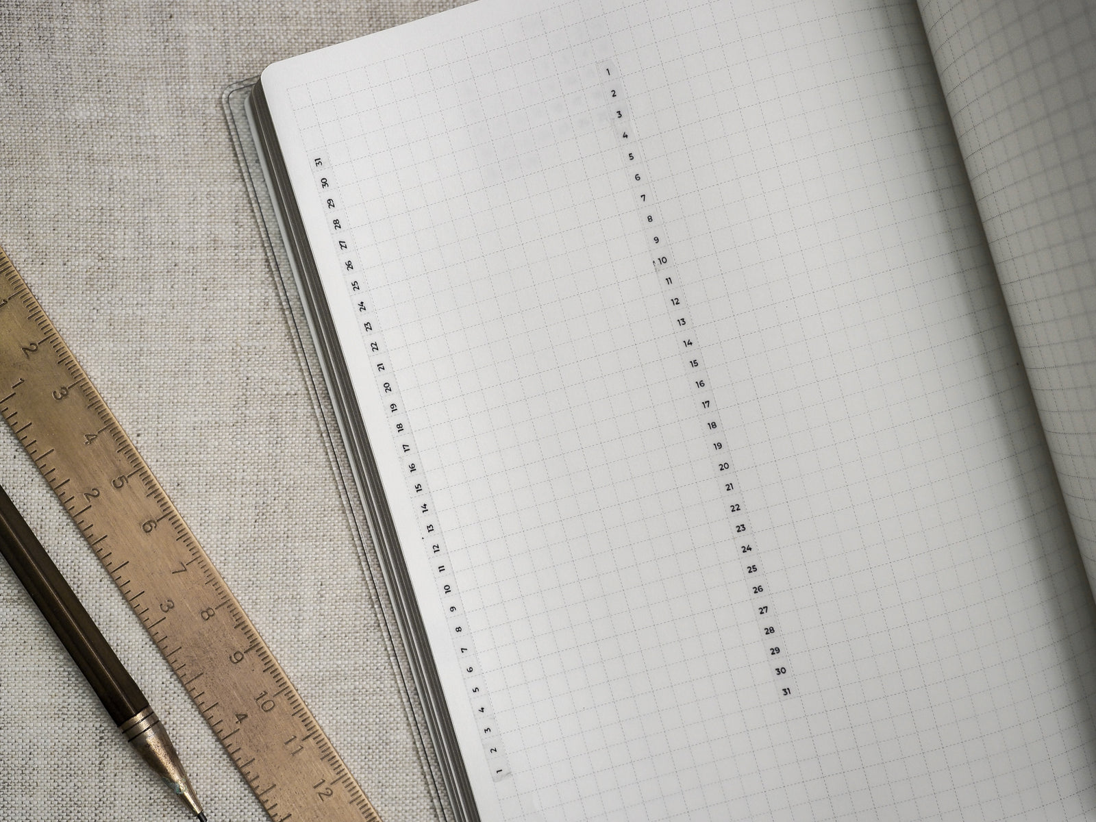 Open planner pages showcasing a clean, light gray gridded design perfect for customizable tracking, planning, and organized note-taking layouts.