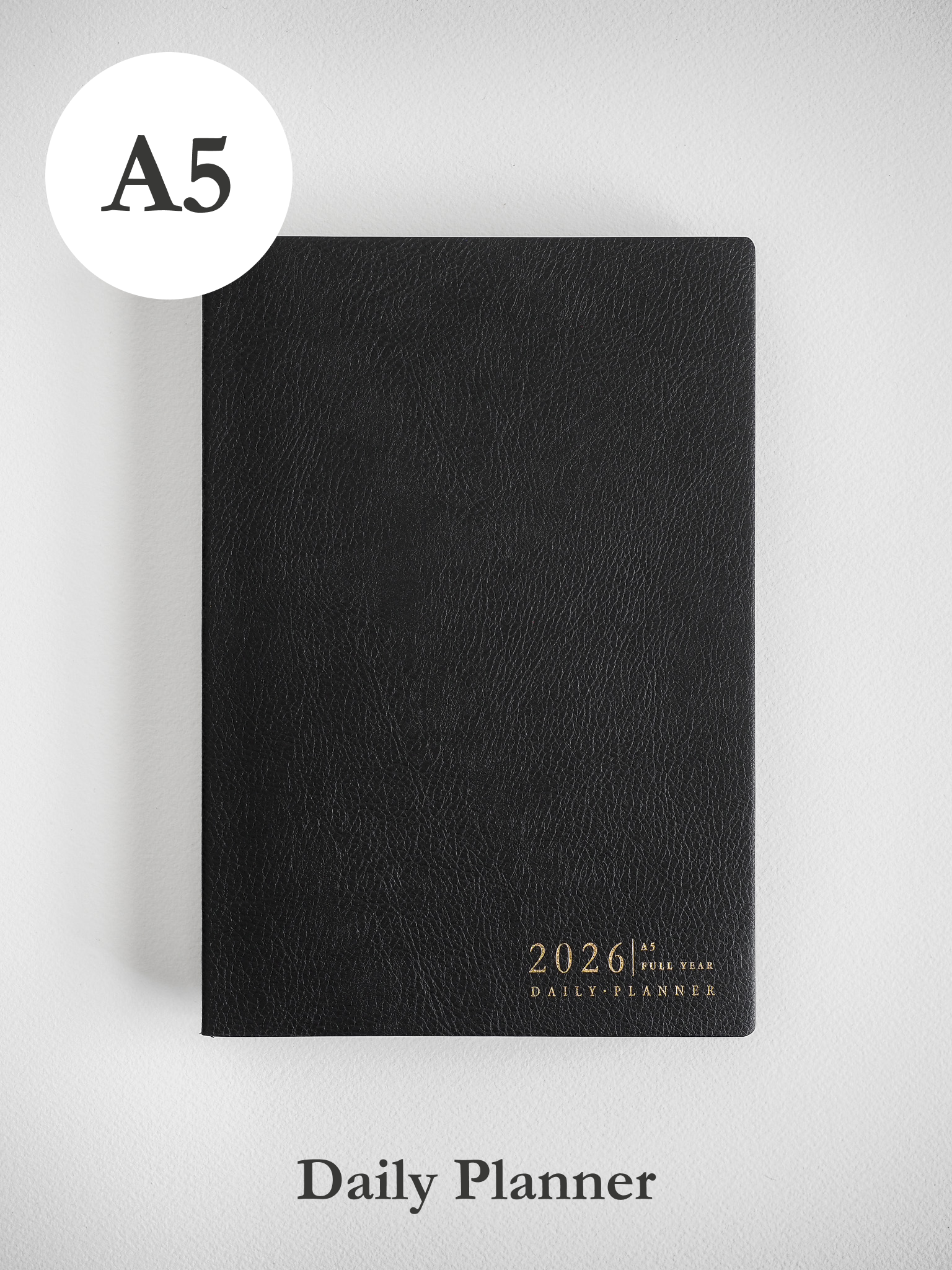 Sleek A5 black daily planner featuring metallic gold foil stamping that prominently displays "2026 Daily Planner" for organization.