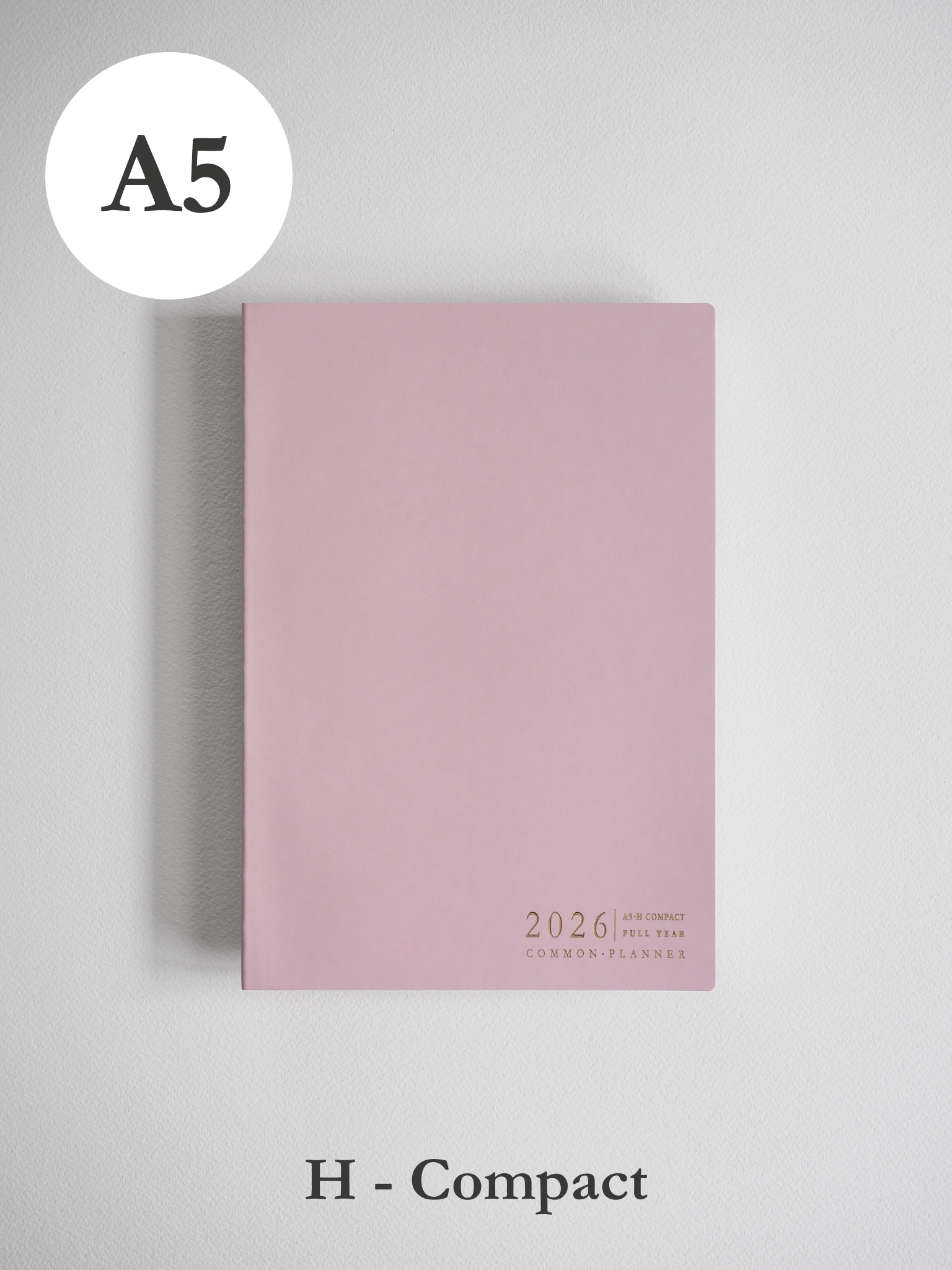 Minimalist A5 planner cover in soft blush pink, featuring subtle centered text that reads "2026 Common Planner."