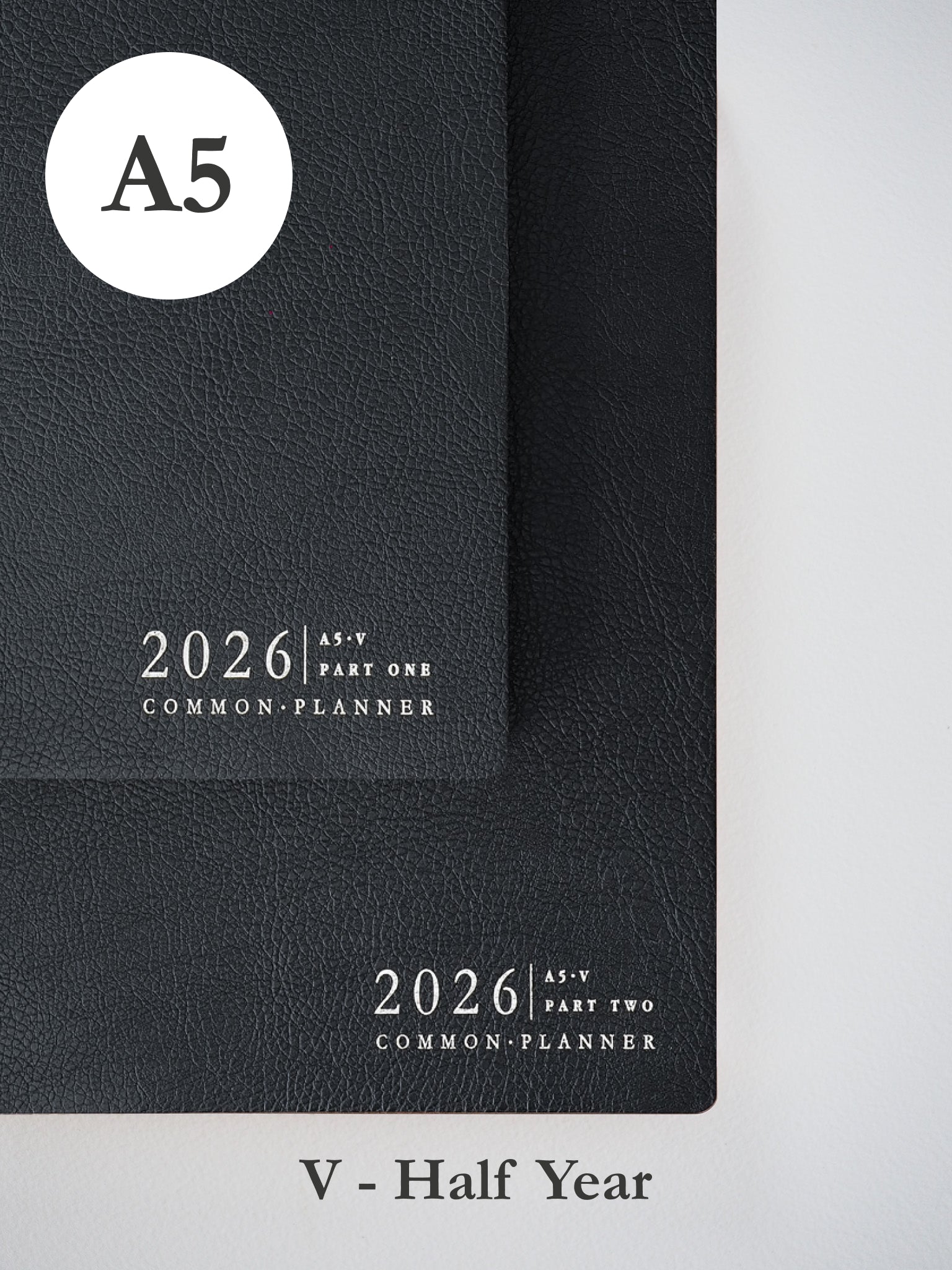 Two stacked black A5 vertical planners for 2026, featuring minimalist embossed white lettering to mark the "Common Planner" for both parts.