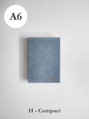 Textured slate blue A6 compact planner featuring elegant gold foil accents and the embossed year 2026 on the durable cover.