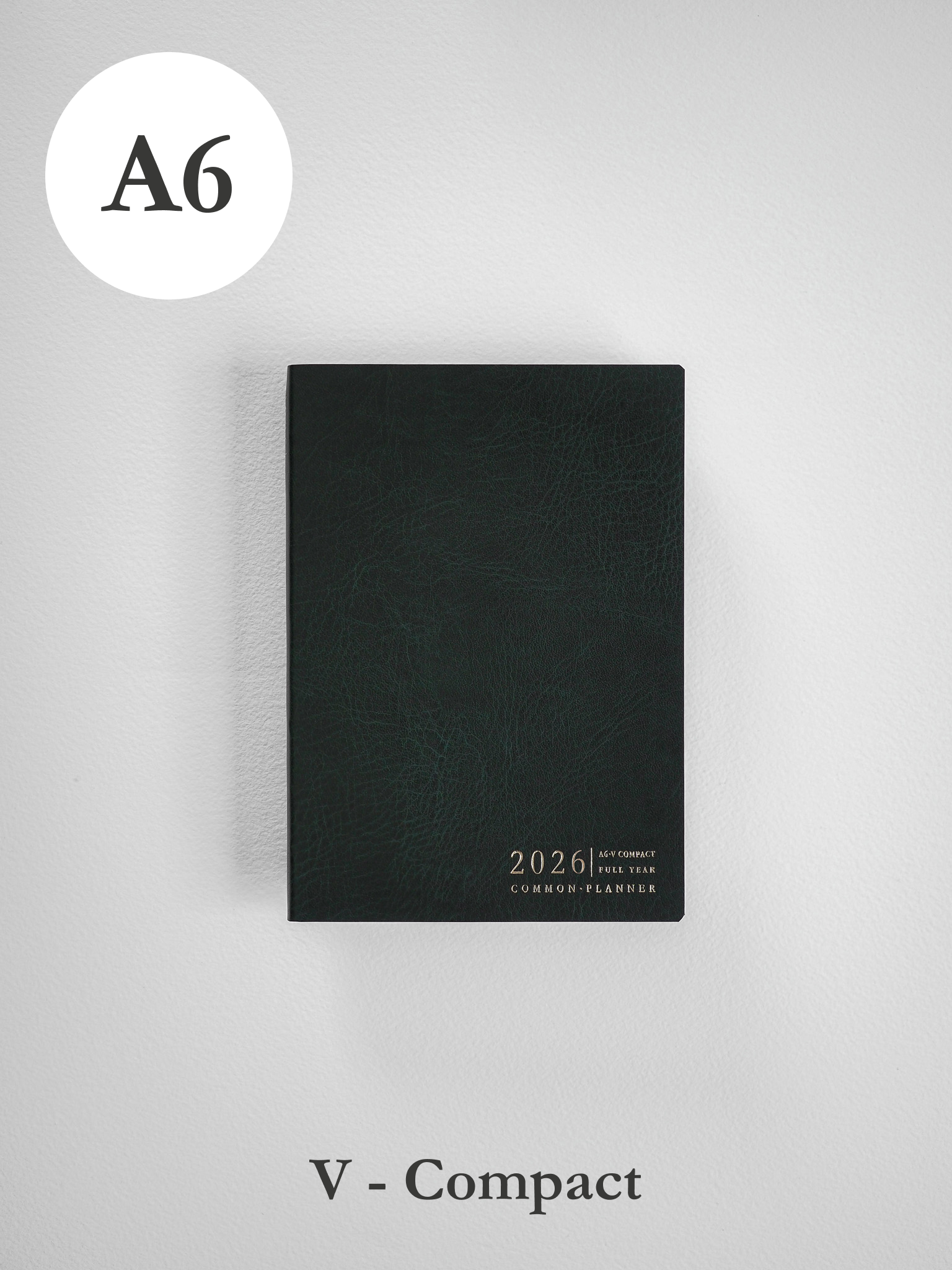 Sleek, dark A6 vertical planner featuring a textured black cover and elegant embossed text indicating the 2026 common planner year.