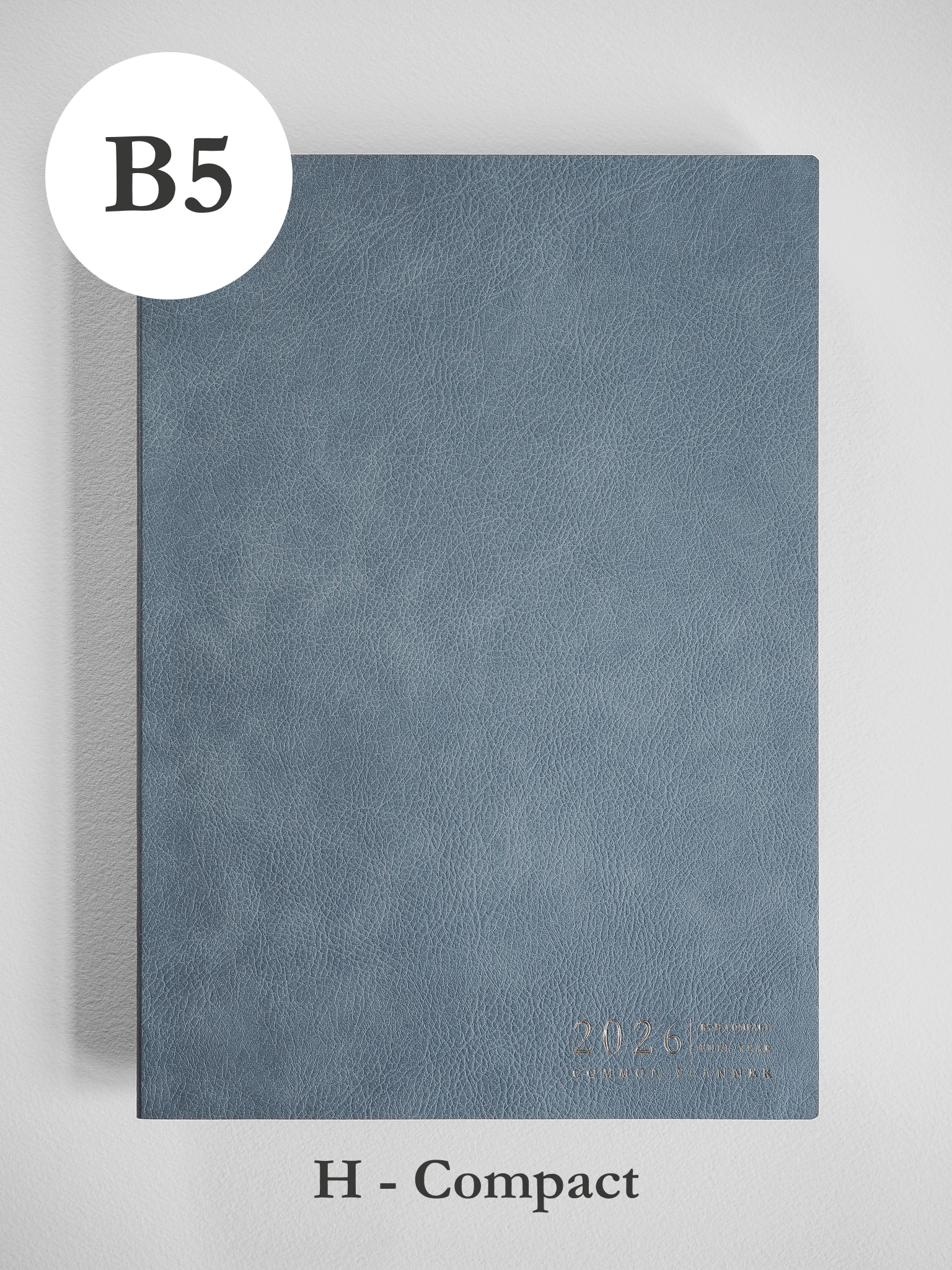 A minimalist B5 planner cover in slate gray features a matte, textured finish and subtle debossed text indicating the year 2026.
