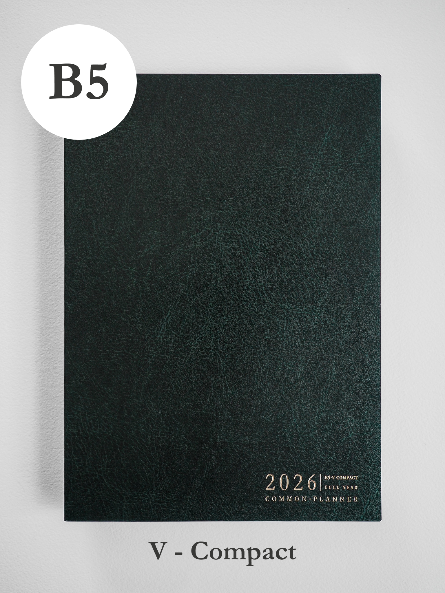 This B5 vertical planner has a deep charcoal, textured faux leather cover featuring subtle graining and minimal white text for 2026.