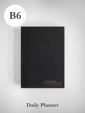 Sleek black B6 daily planner with a matte, textured cover, featuring white embossed text that reads 2026 Full Year Daily Planner.