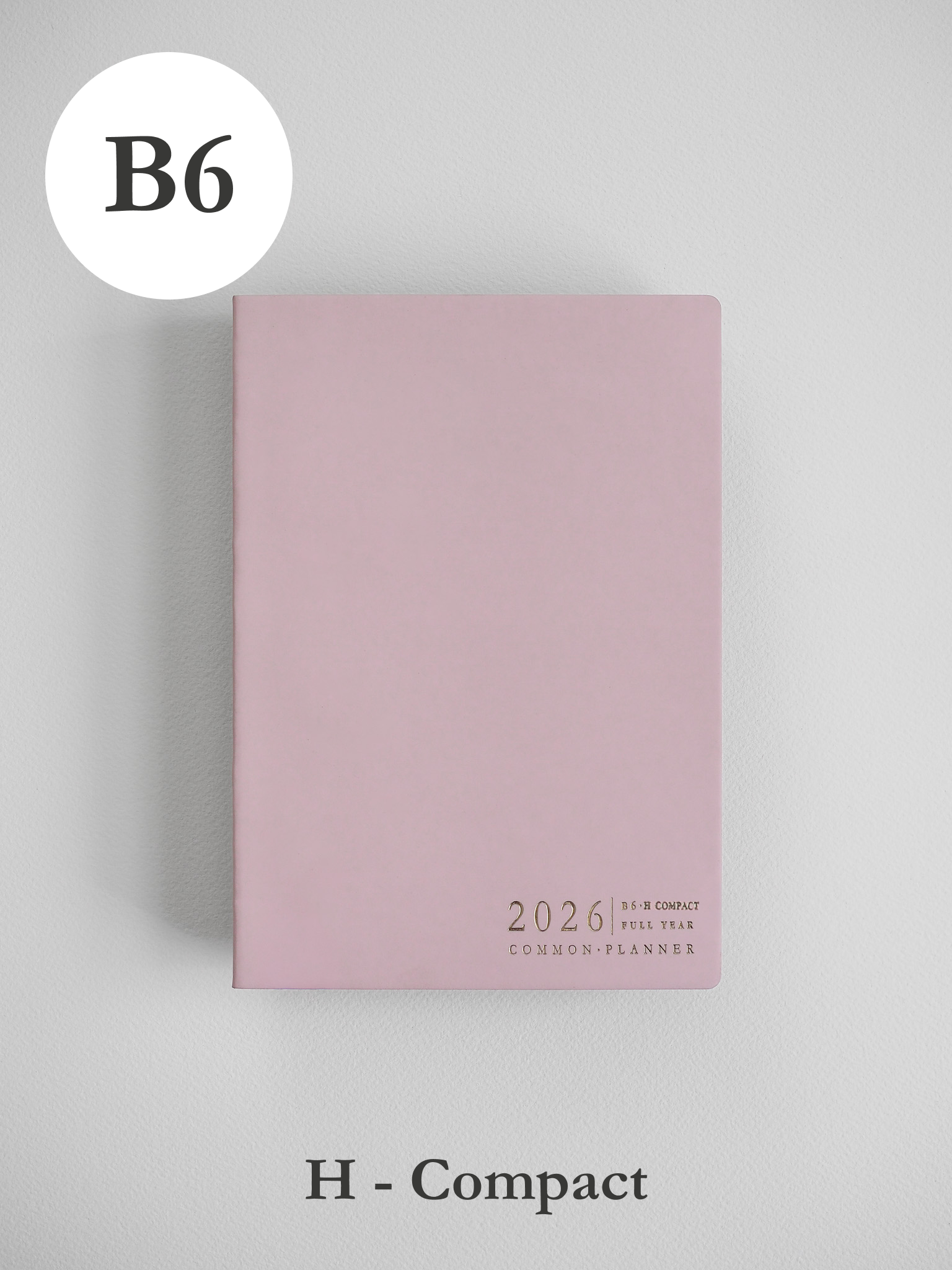 Soft blush pink B6 planner cover displaying minimalist black lettering for the 2026 Common Planner.