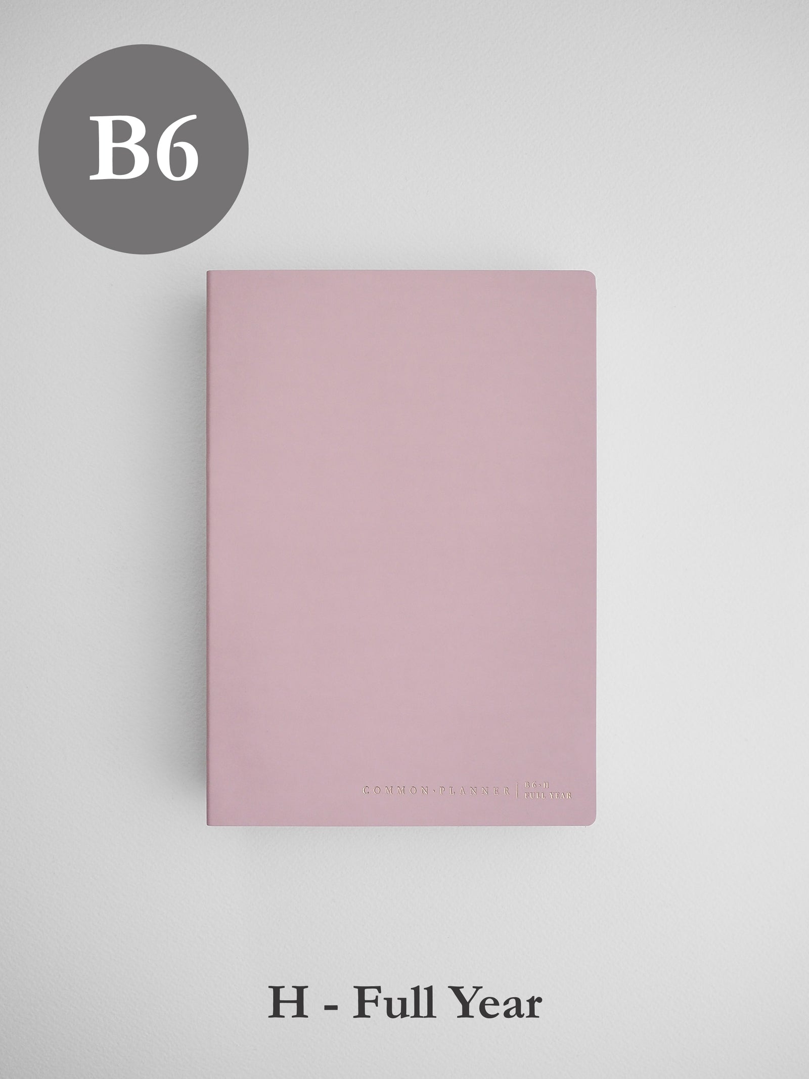 Minimalist B6 horizontal planner cover in dusty blush pink, featuring a solid, elegant surface and small branding at the bottom.