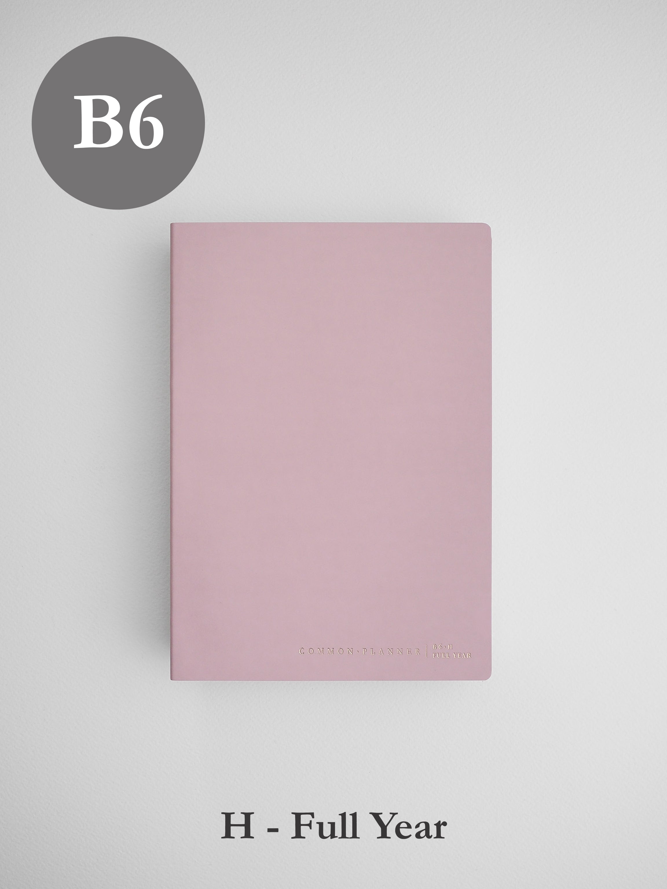 Minimalist B6 horizontal planner cover in dusty blush pink, featuring a solid, elegant surface and small branding at the bottom.