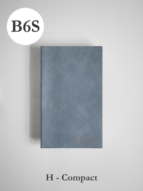 Minimalist B6 compact planner featuring a textured slate-blue cover and discreet embossed year markings for 2026 organization.