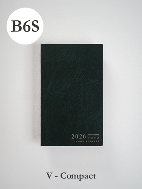 Deep, textured dark green planner cover with minimalist metallic typography centered on the front, displaying "2026 B6 Slim Compact Full Year Common Planner."