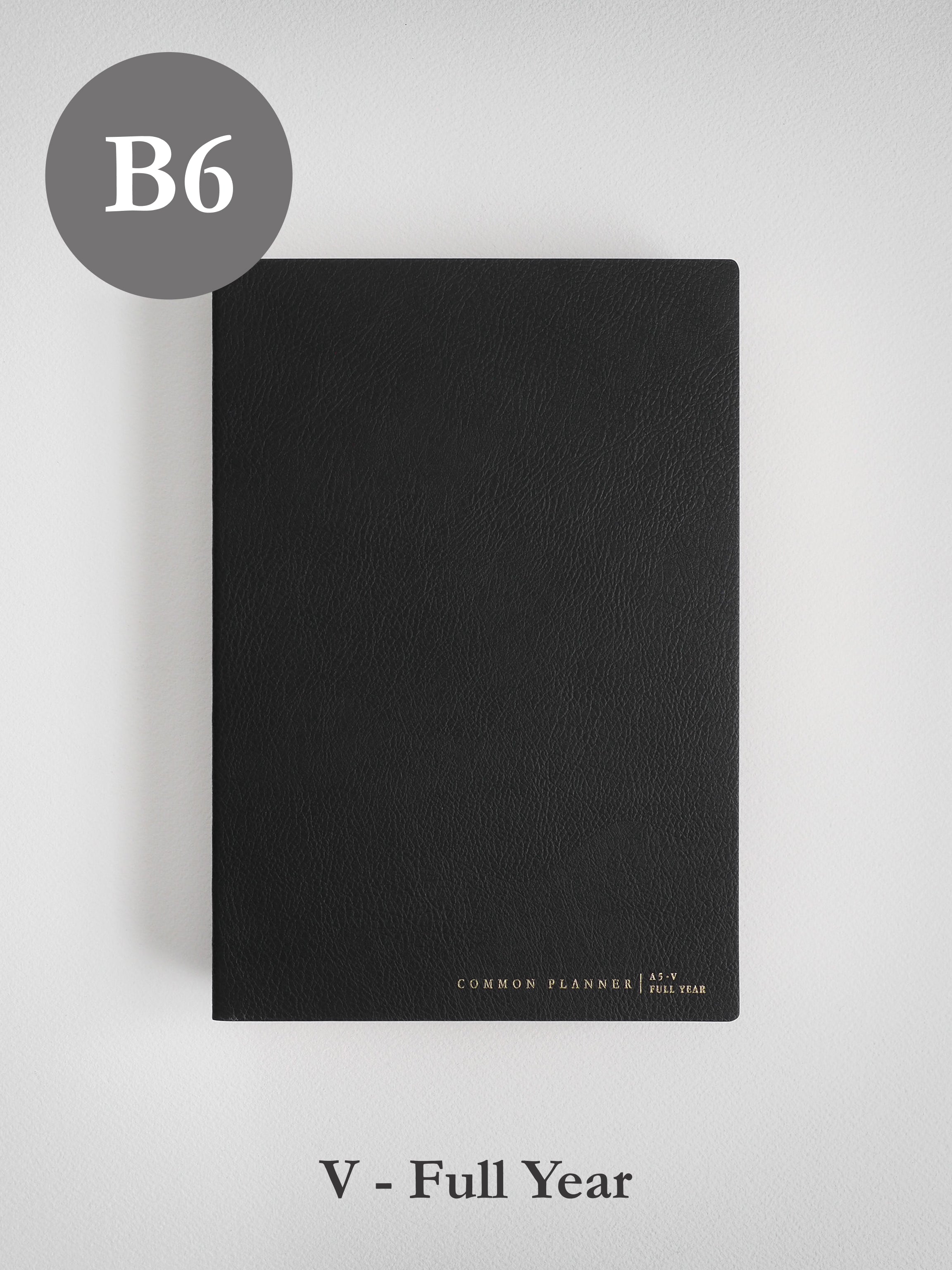 Minimalist black B6 planner cover with a smooth, faux leather finish, featuring subtle branding for the "Common Planner | As-V Full Year" theme.